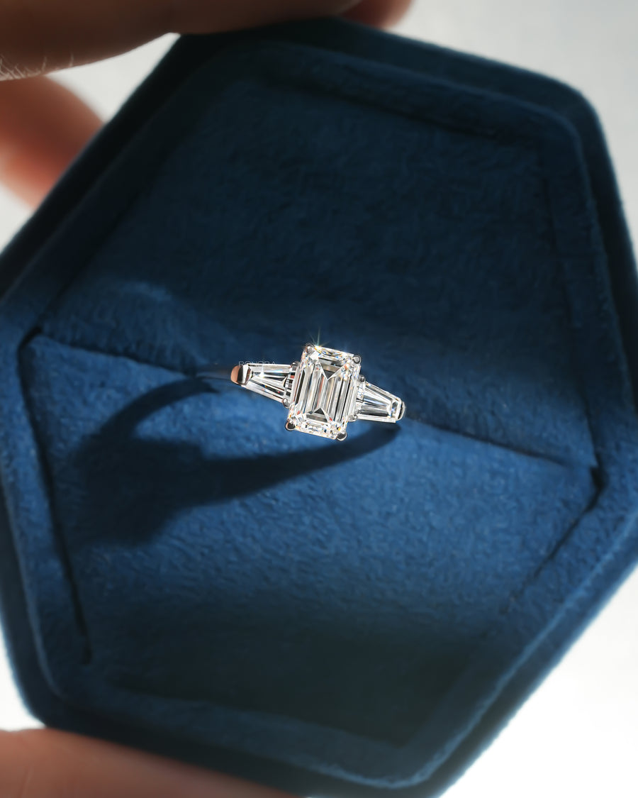 Emerald cut lab grown diamond three stone ring in white gold with tapered side stones, in a blue velvet ring box