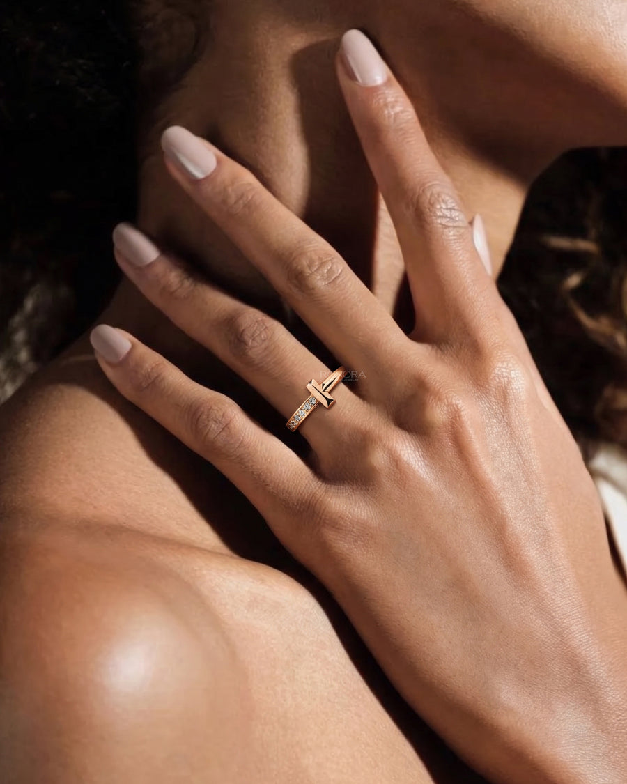 Hand at the neck wearing a rose gold flat bar lab grown diamond ring with a dainty pave stacking band
