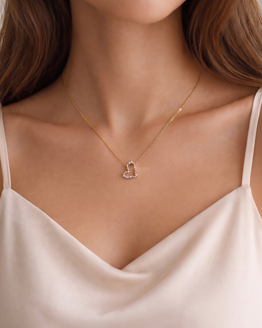Model wearing an open heart lab grown diamond pendant necklace with mixed shape stones on a gold chain