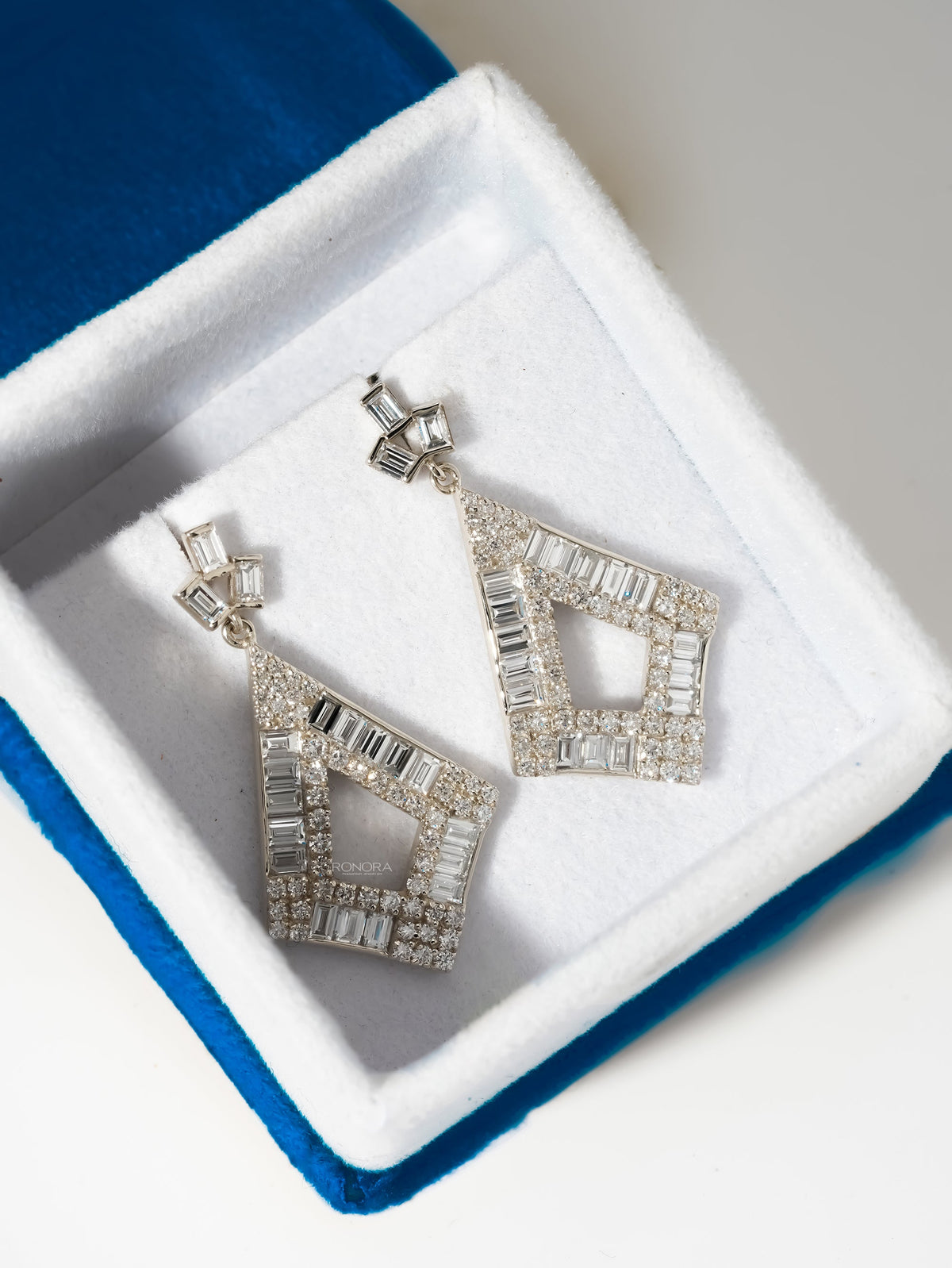 Baguette lab grown diamond drop earrings in a kite shape, white gold, resting in a white velvet jewelry box