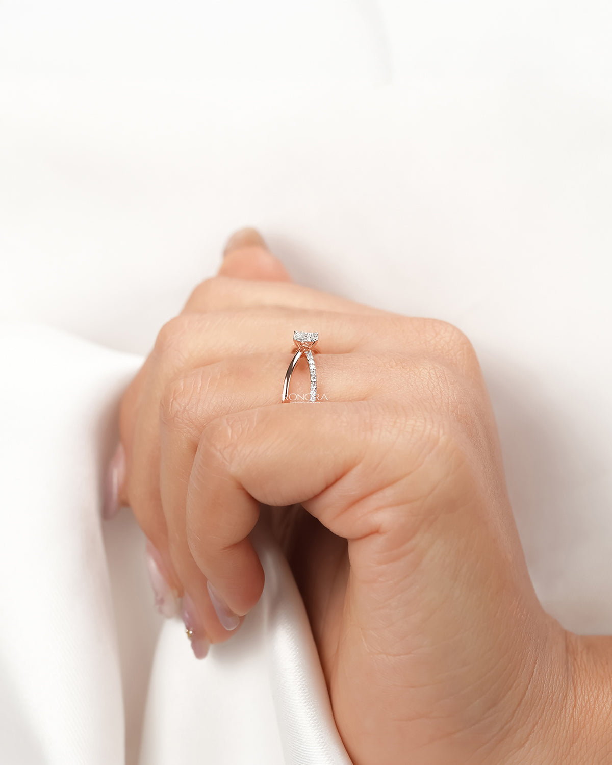Round lab grown diamond split-shank ring worn with white silk
