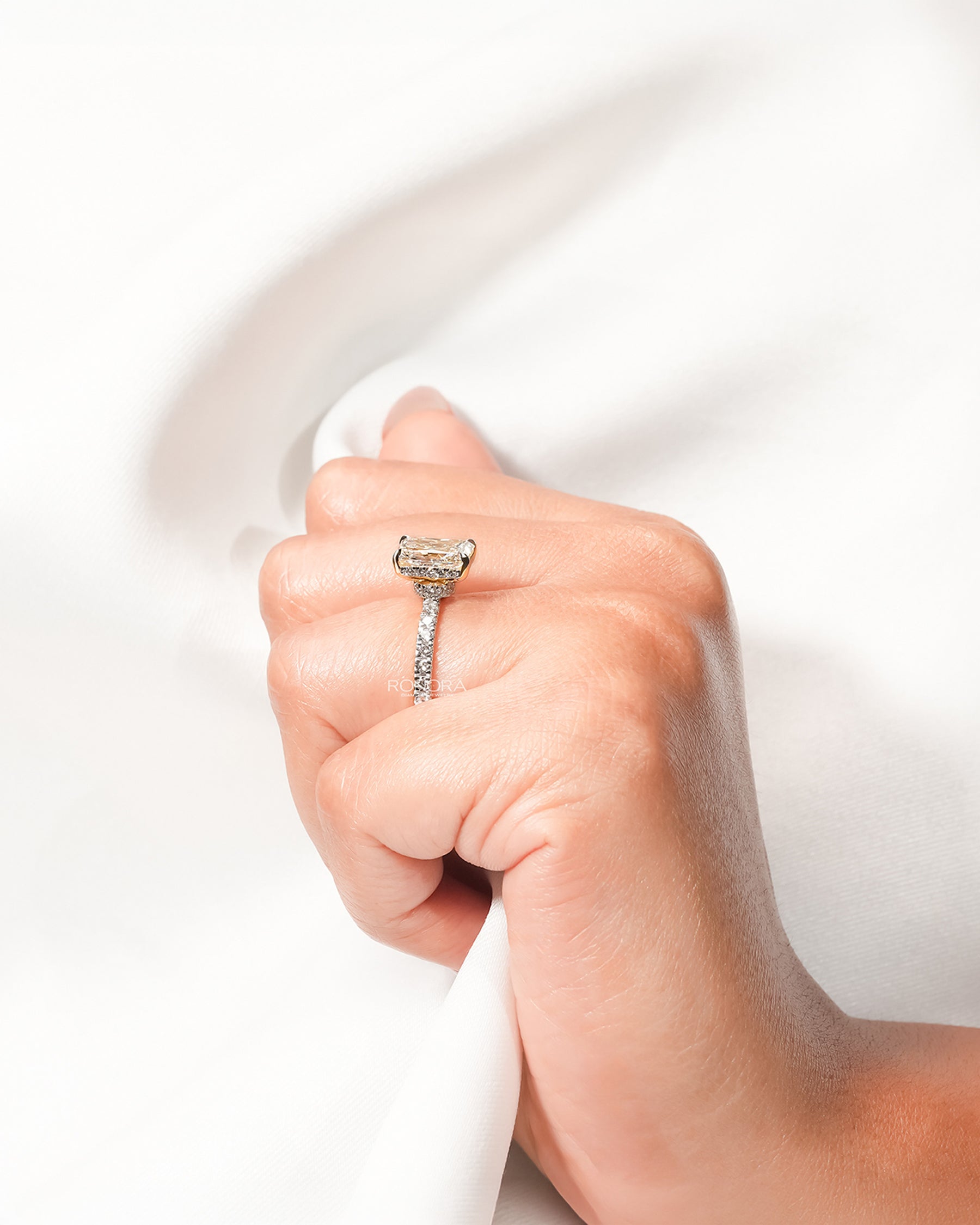 Radiant lab grown diamond pavé ring worn with white silk