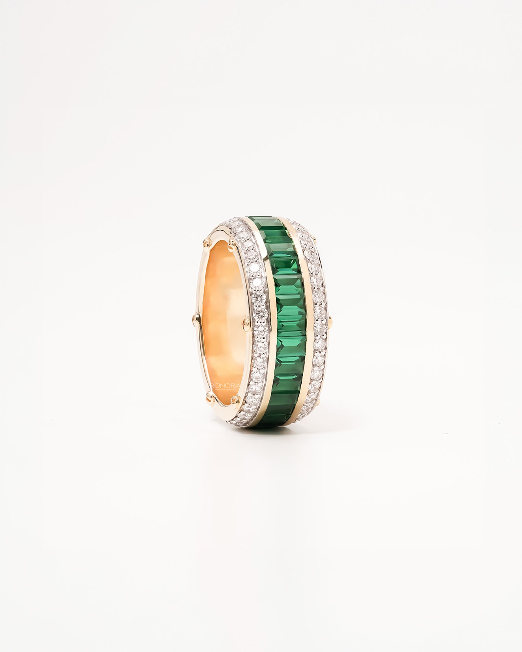 Angled view of green lab grown diamond channel band showing channel and pavé setting