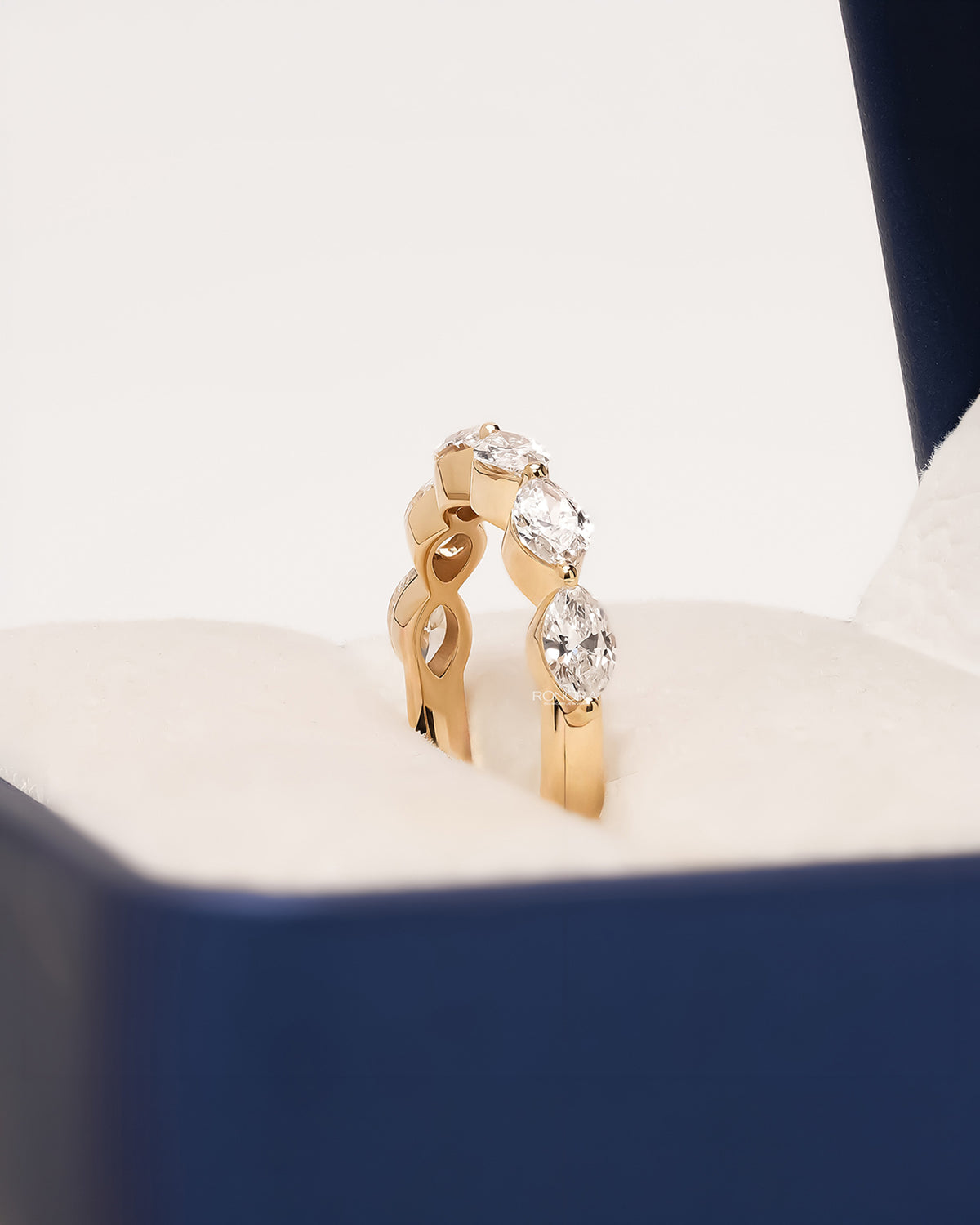 Angled view of round lab grown diamond five-stone band showing graduated shared-prong setting