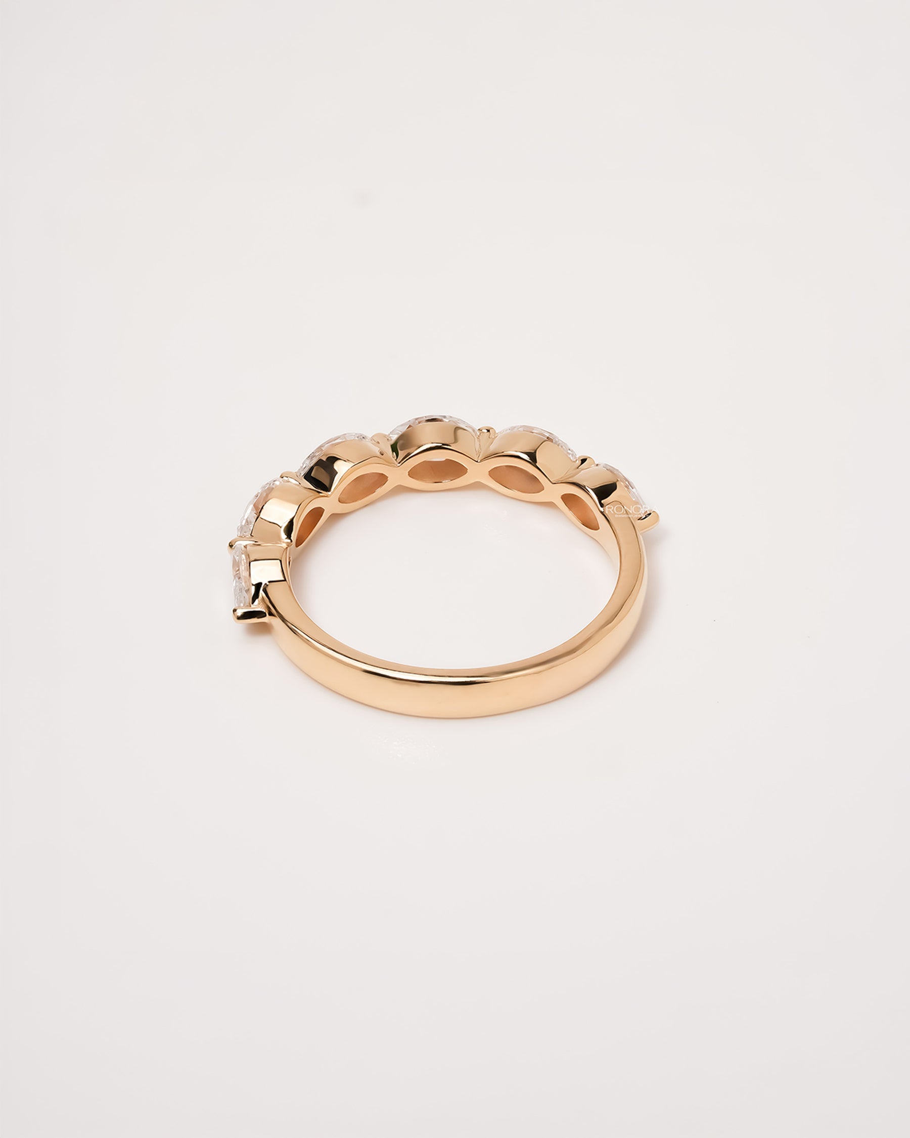 Side profile of round lab grown diamond five-stone band showing graduated shared-prong setting