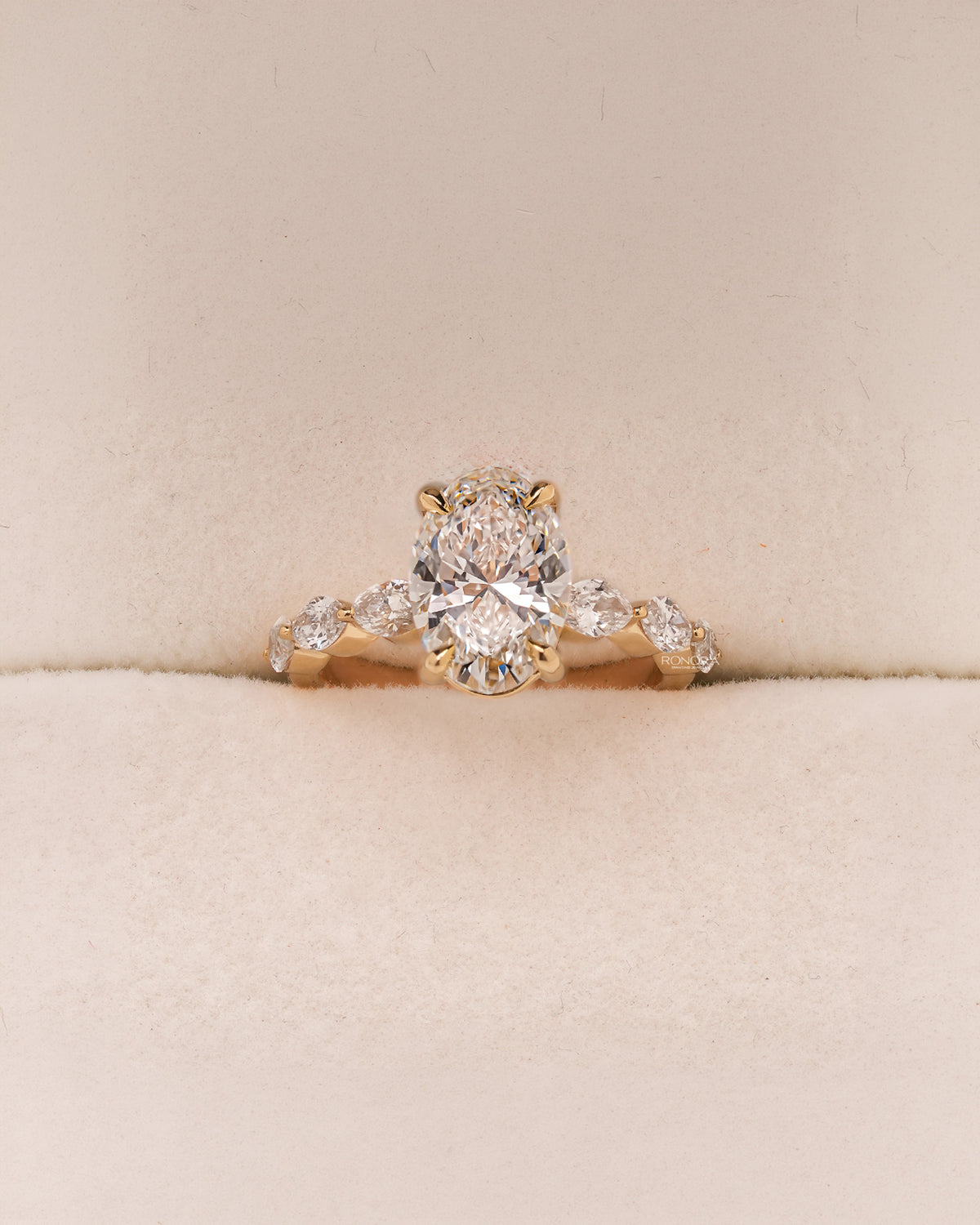 Celeste oval lab grown diamond side-stone ring in yellow gold inside Ronora box