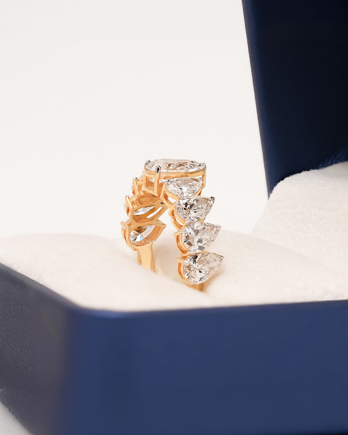 Angled view of pear lab grown diamond five-stone band showing graduated shared-prong setting