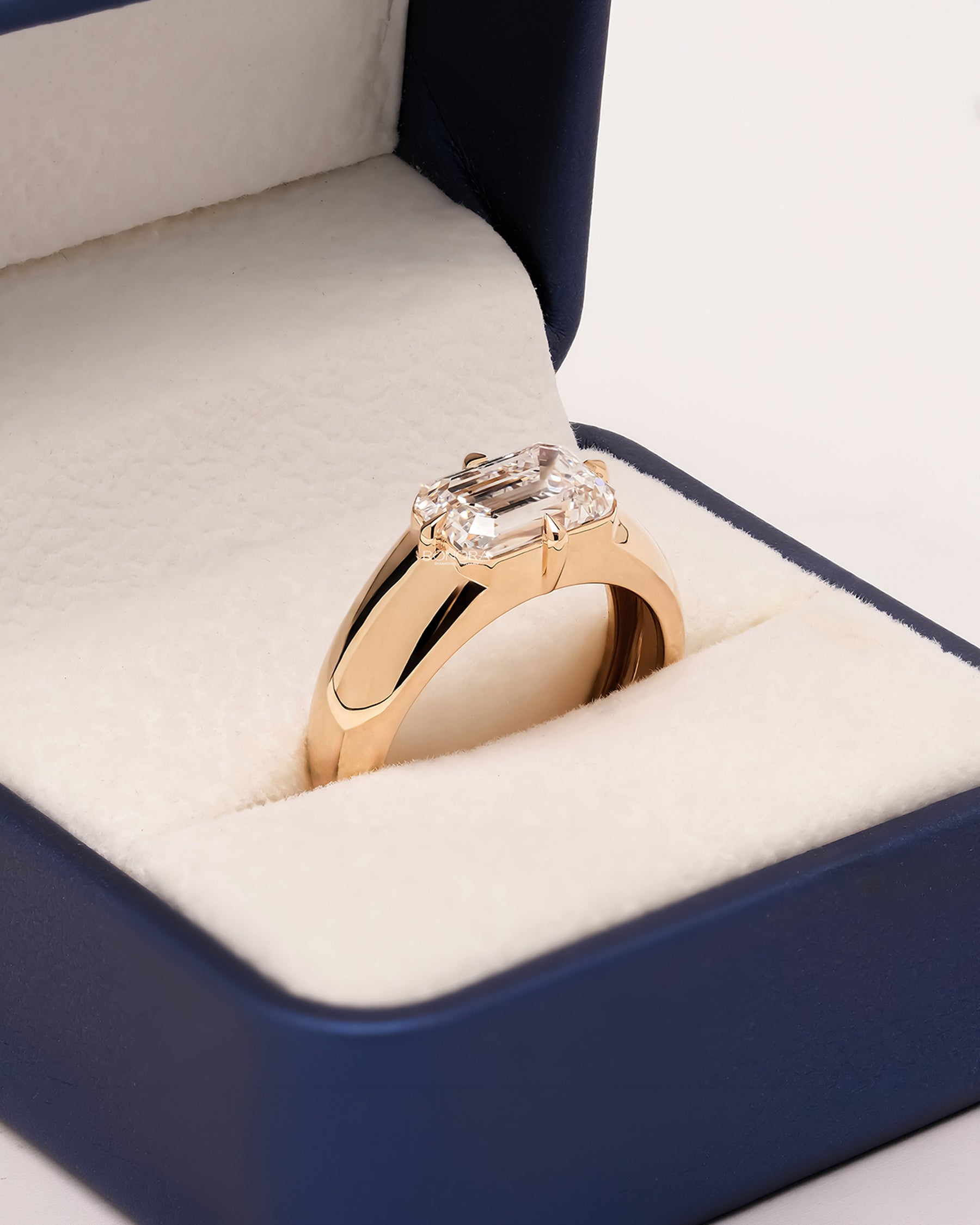 Emerald lab grown diamond signet ring worn on hand in yellow gold