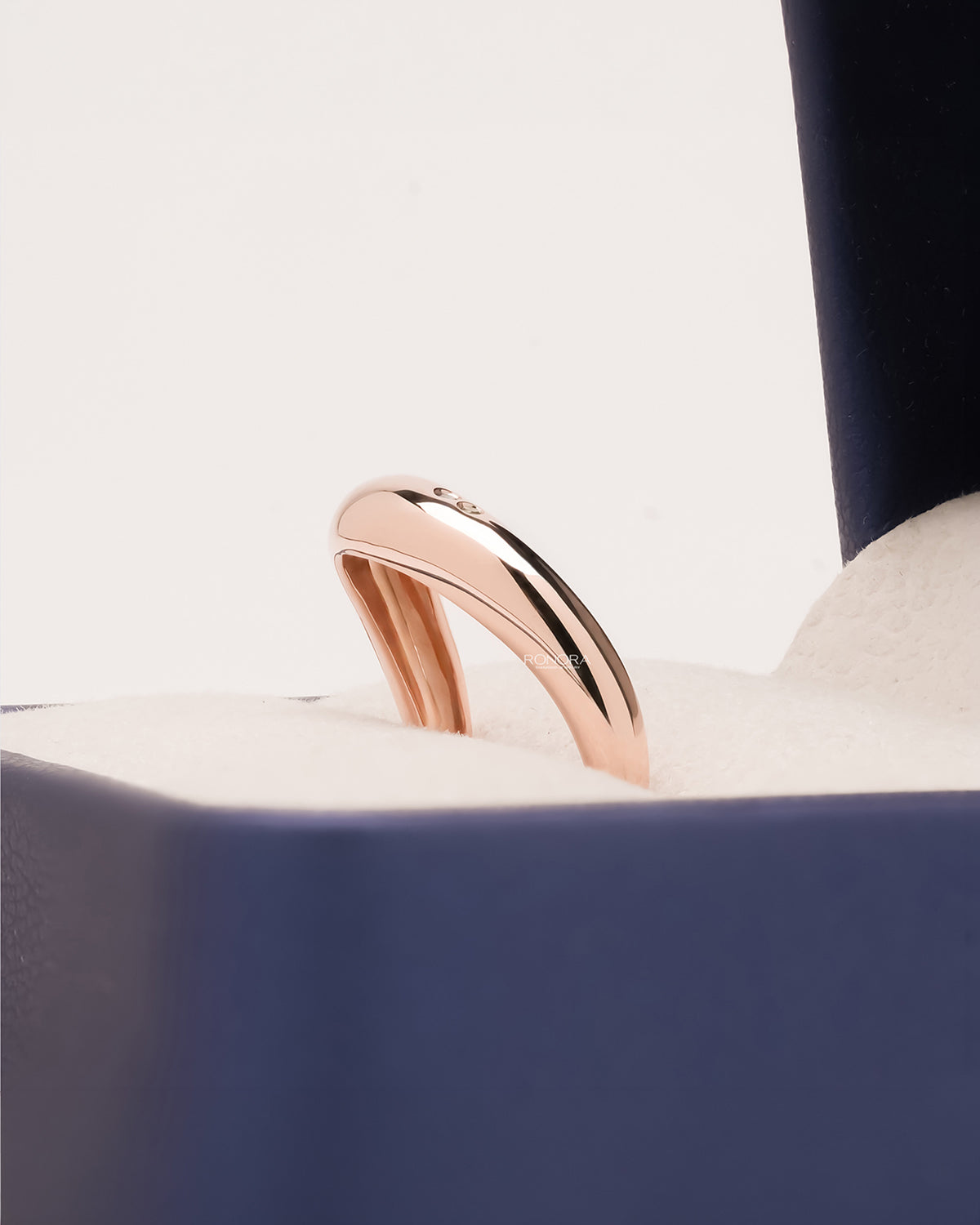 Side profile of blue accent lab grown diamond curved ring showing minimal accent setting