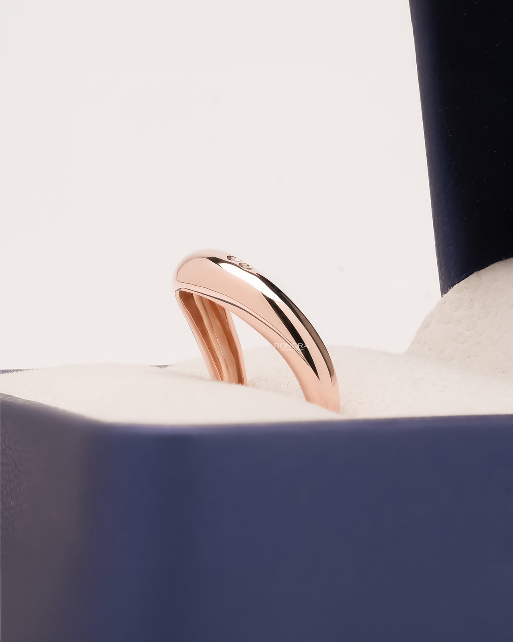 Side profile of blue accent lab grown diamond curved ring showing minimal accent setting