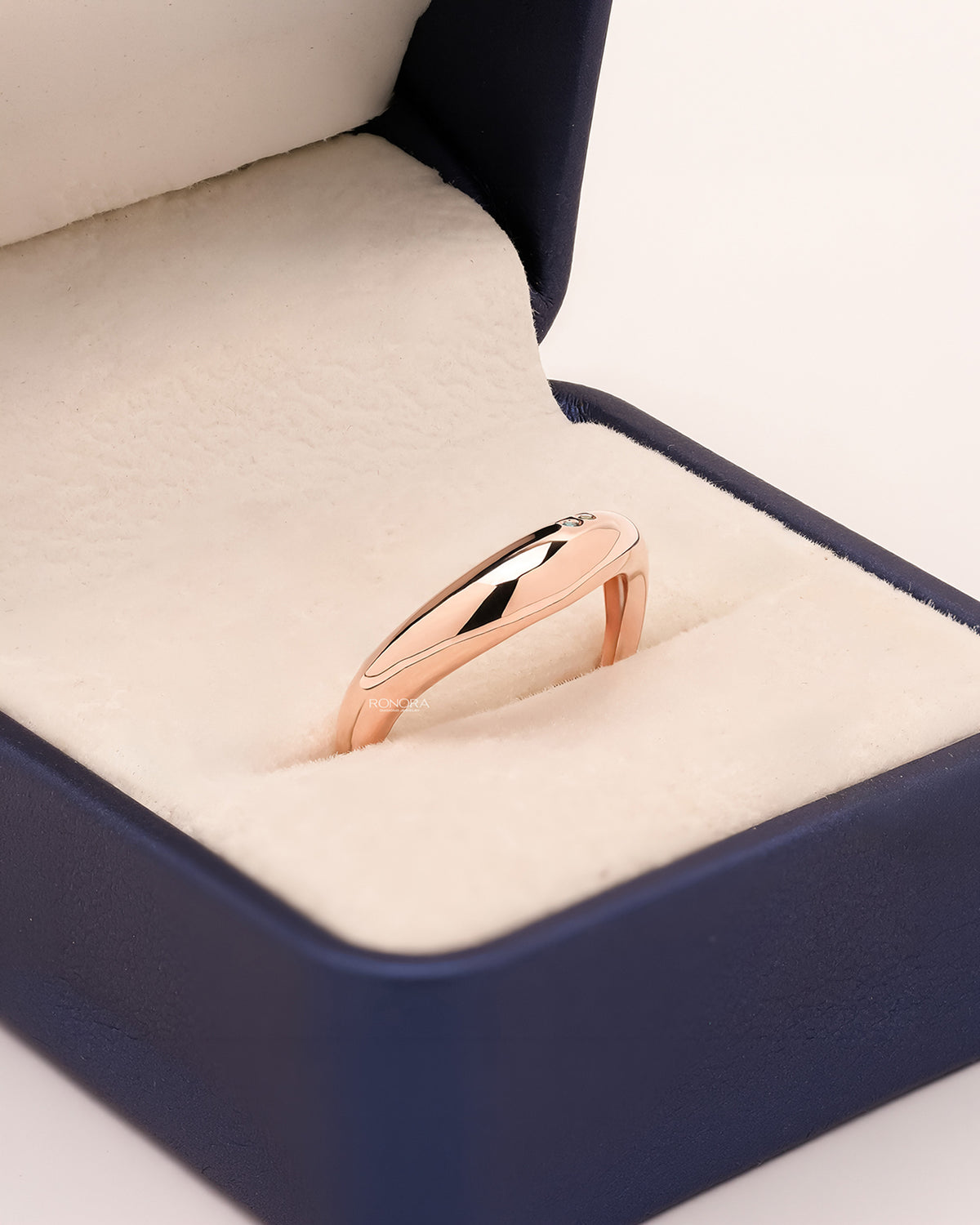 Angled view of blue accent lab grown diamond curved ring showing minimal accent setting