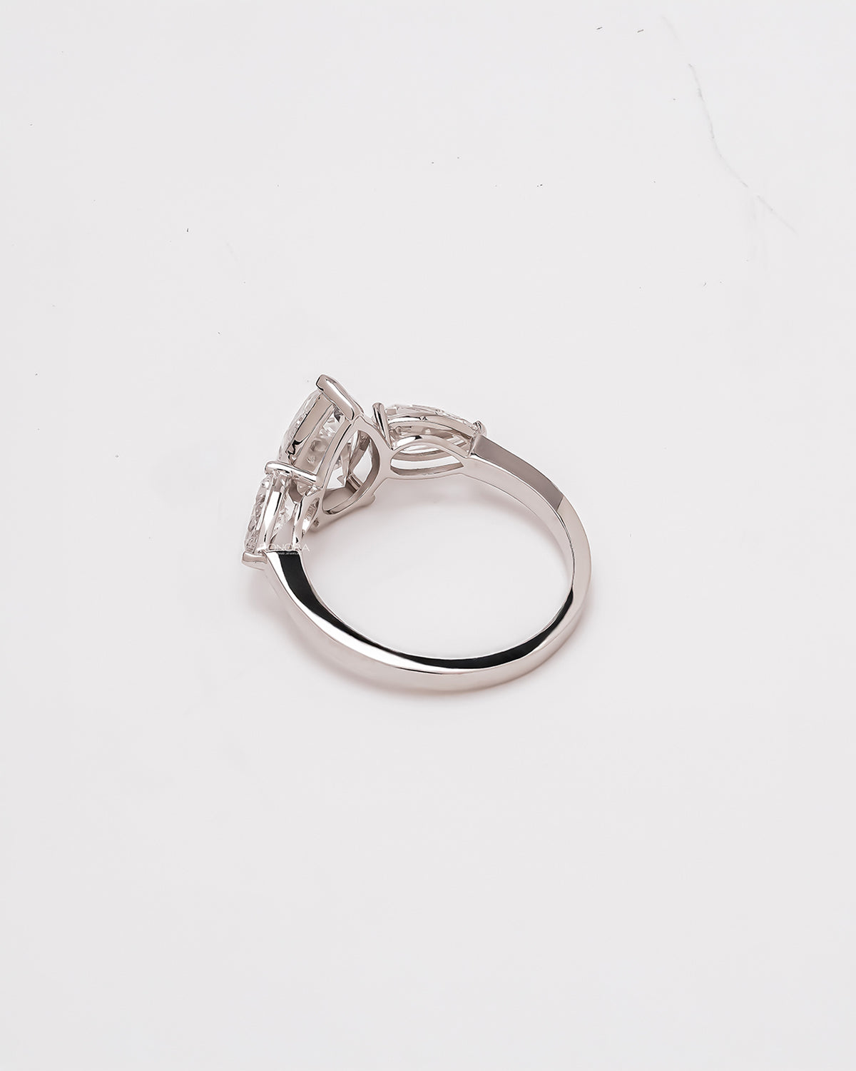 Side profile of pear lab grown diamond three-stone ring showing three-stone setting