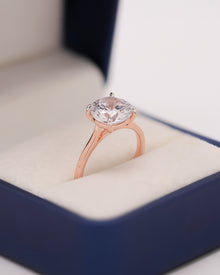 Round moissanite solitaire ring in Ronora box showing prong setting