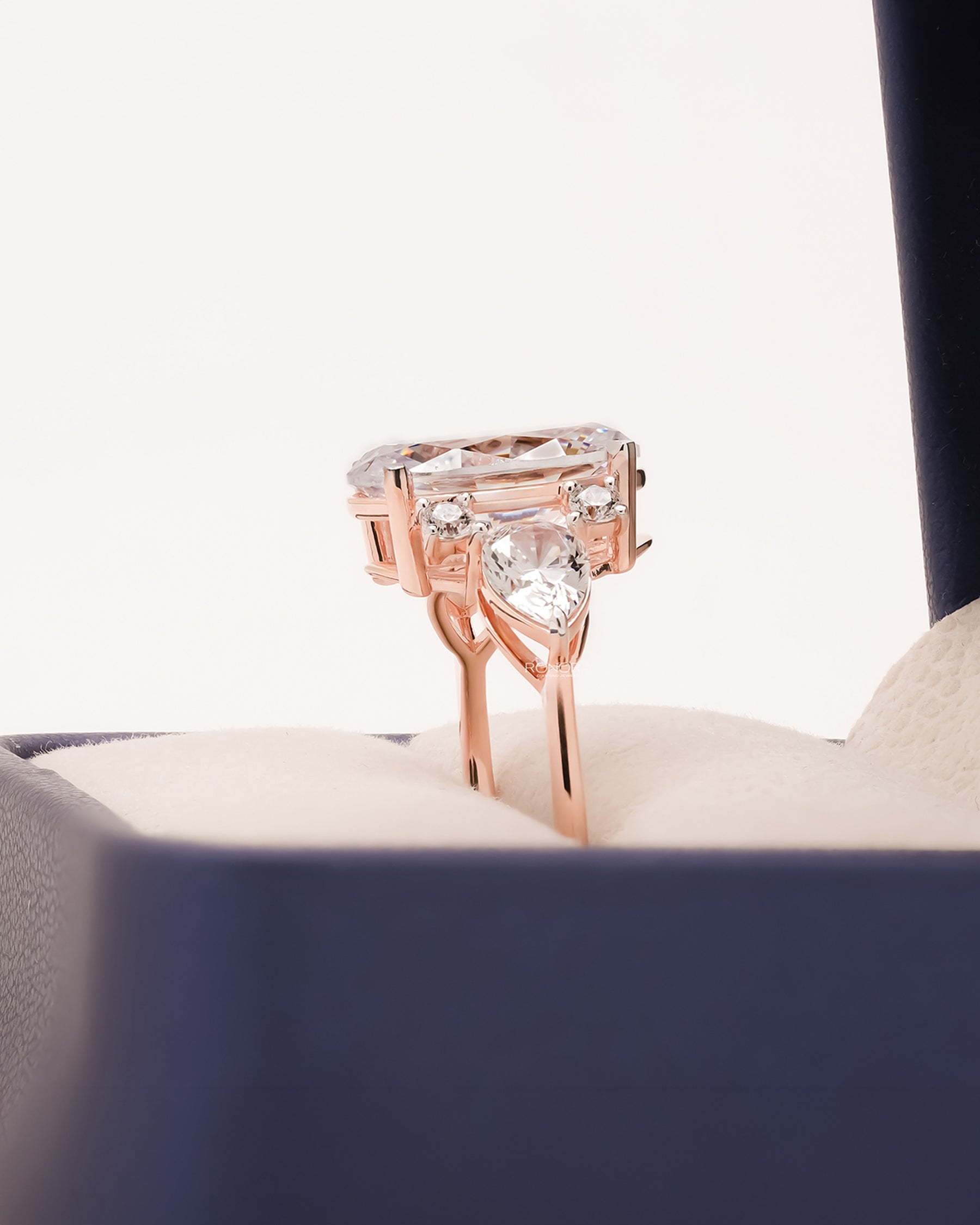 Side profile of oval moissanite three-stone ring showing high-set center
