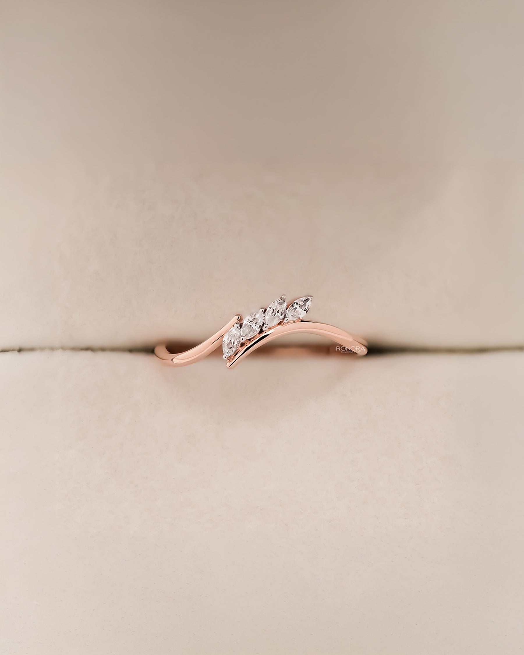 Angled view of marquise lab grown diamond curved ring with curved band setting