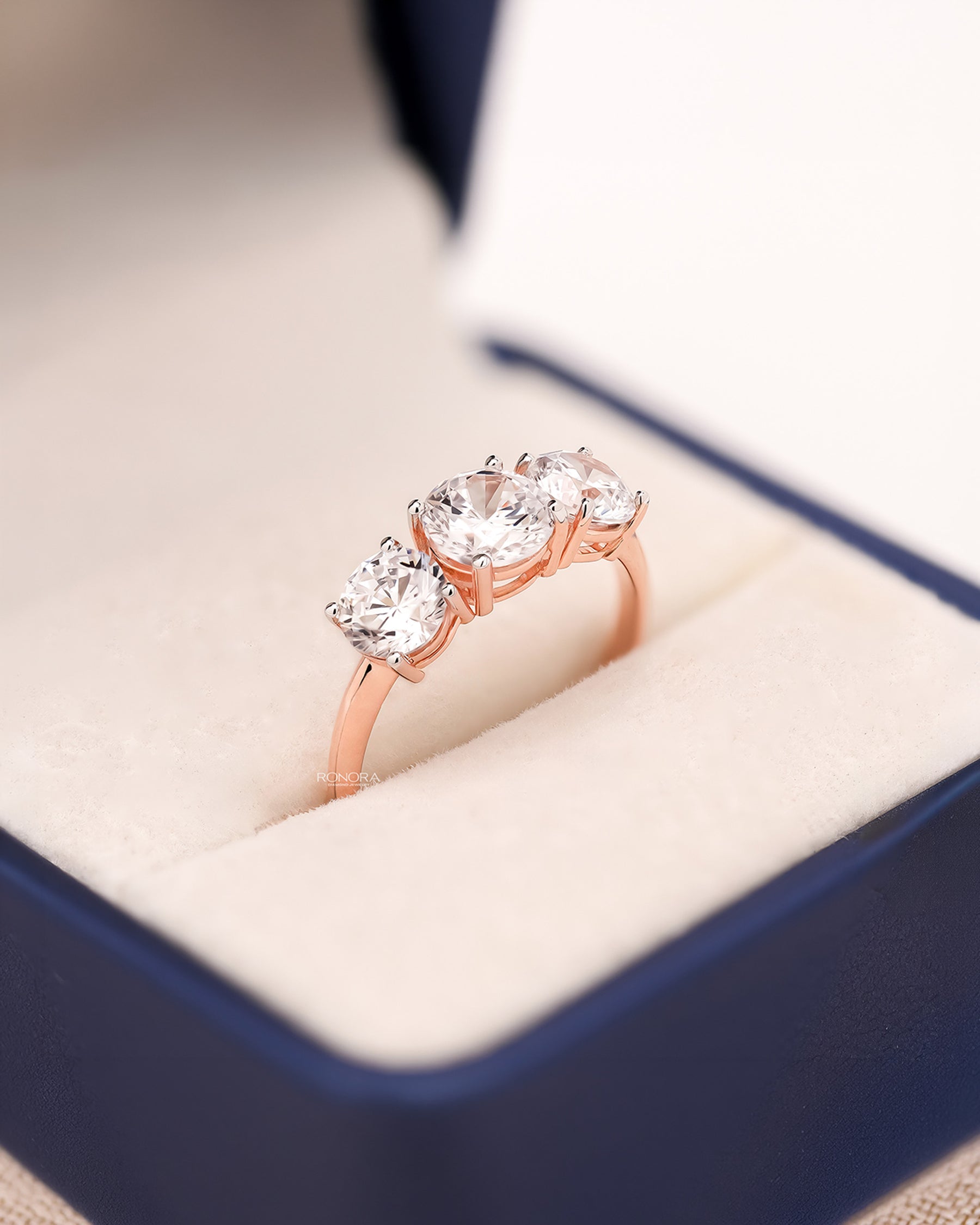 Angled view of round lab grown diamond three-stone ring with three-stone setting