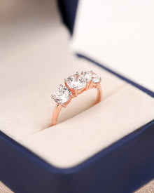 Angled view of round lab grown diamond three-stone ring with three-stone setting