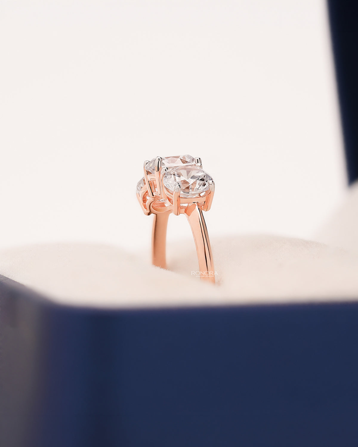 Side profile of round lab grown diamond three-stone ring showing ring setting