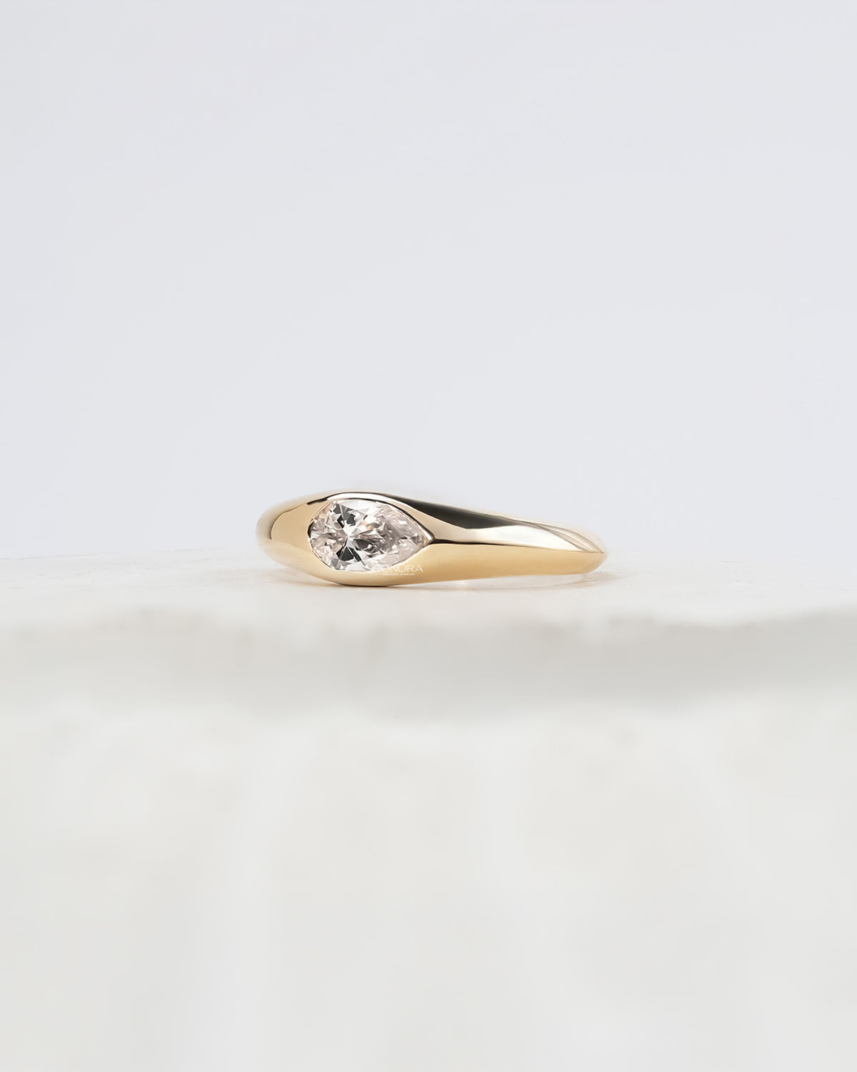 Angled view of pear lab grown diamond bezel ring with bezel setting