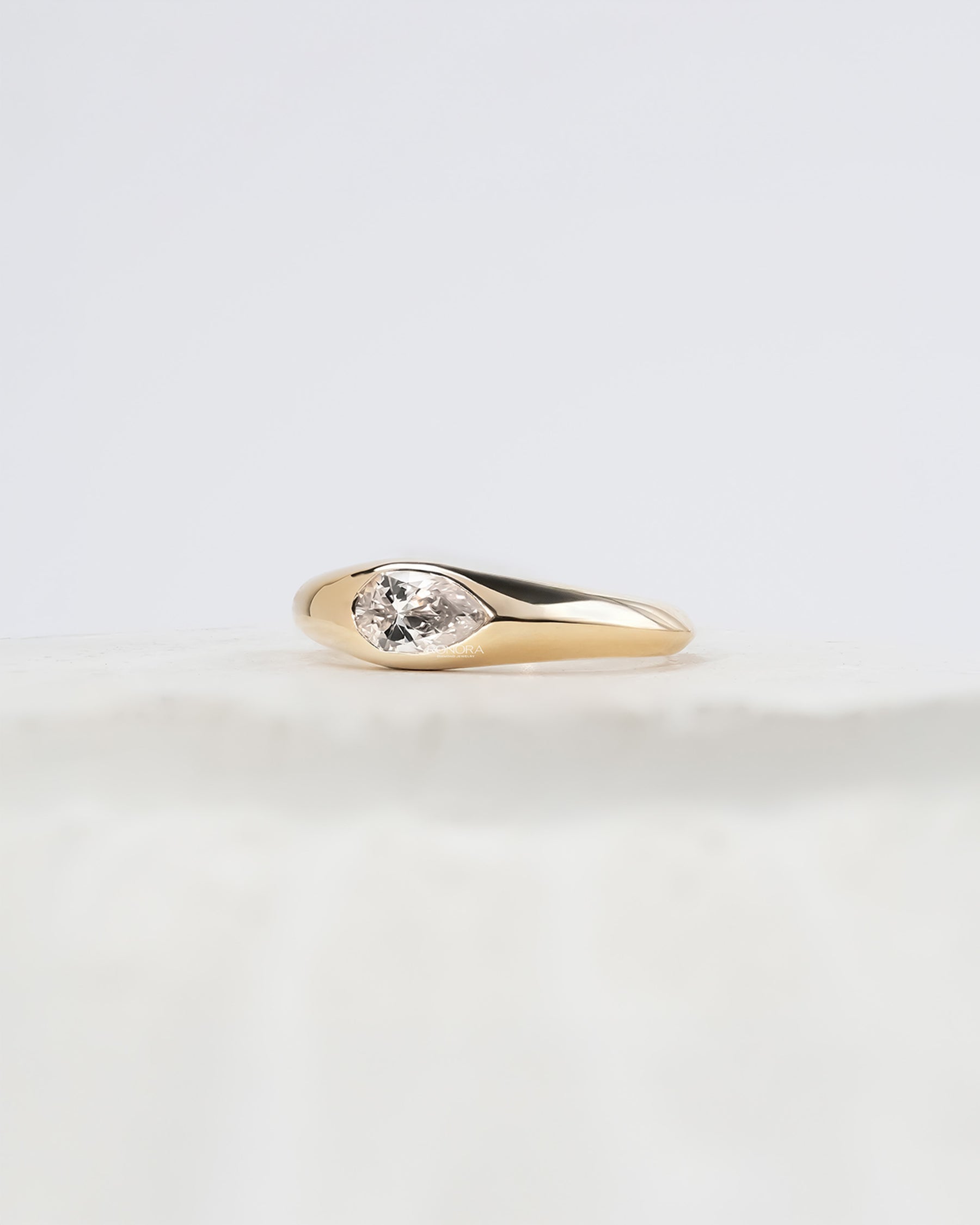 Angled view of pear lab grown diamond bezel ring with bezel setting