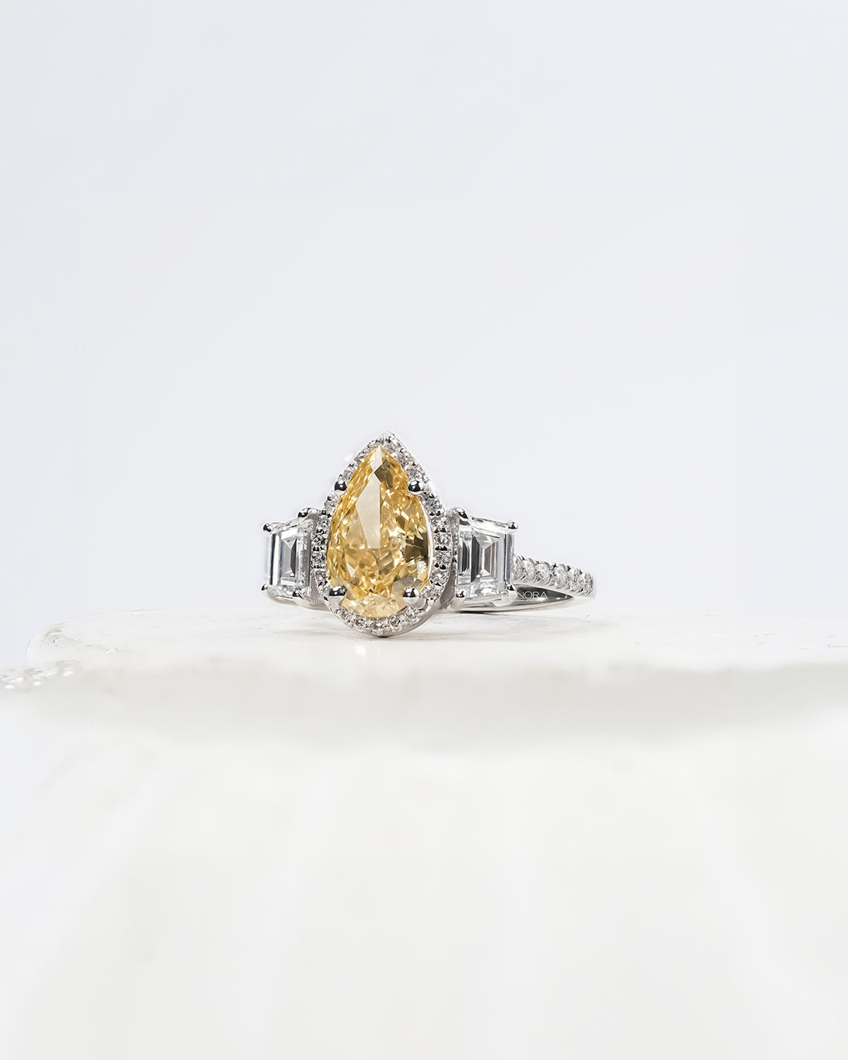 yellow pear lab grown diamond halo ring worn with luxury styling in white gold