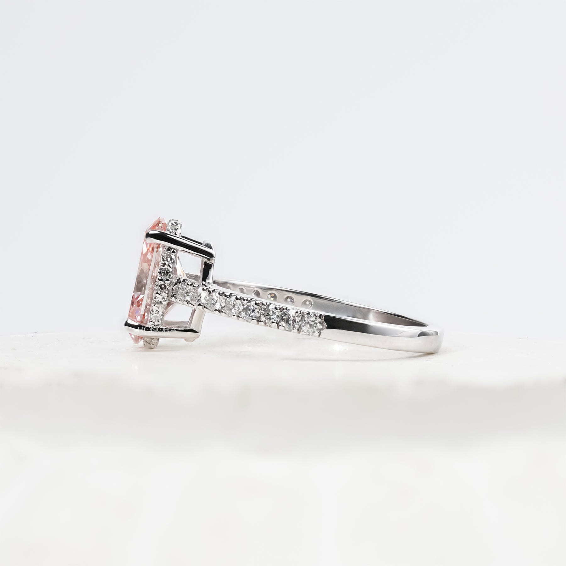 pink oval lab grown diamond halo ring worn with luxury styling in white gold
