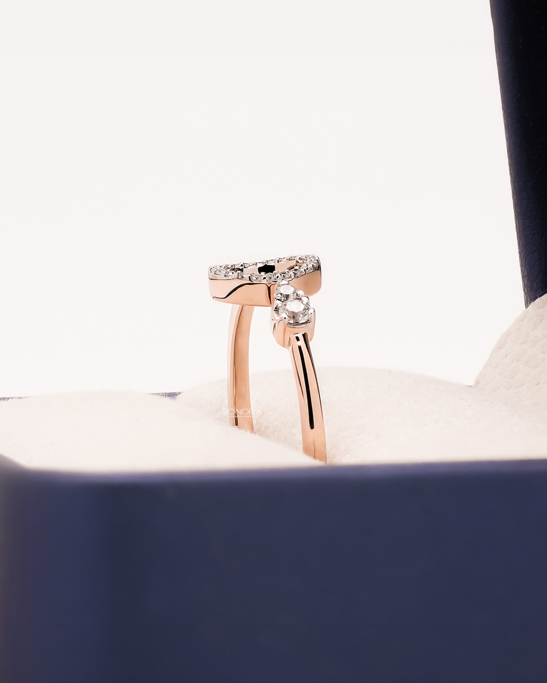 Side profile of round lab grown diamond open halo ring in Ronora box