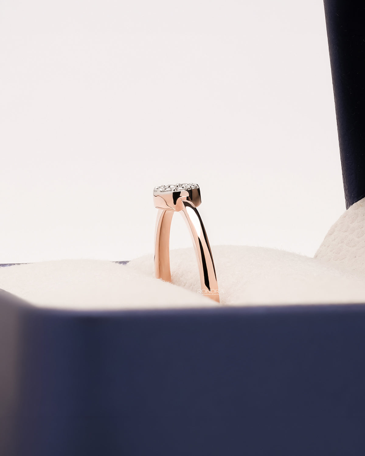 Side profile of round lab grown diamond halo ring in Ronora box
