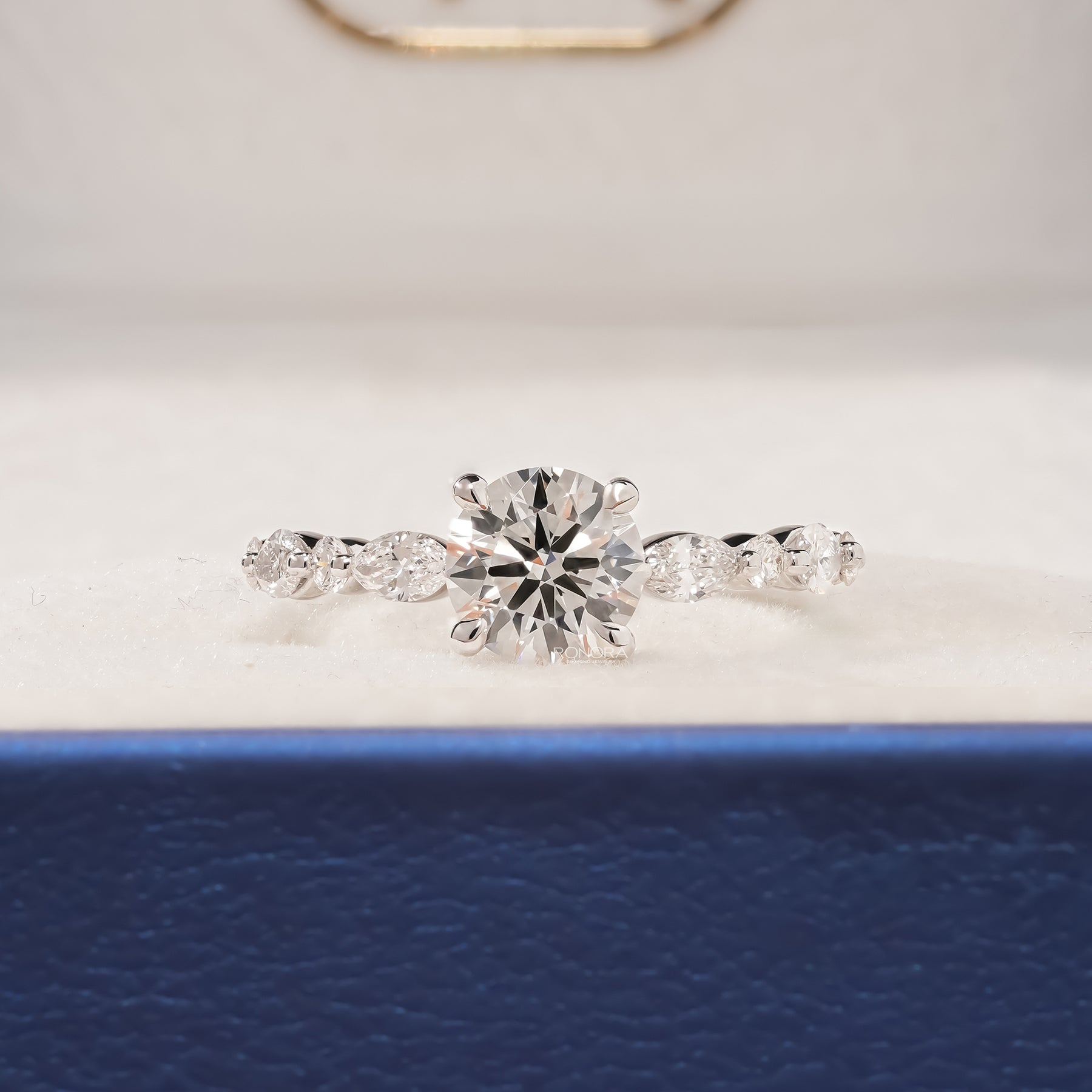 Isabelle round lab grown diamond side-stone ring in white gold inside Ronora box