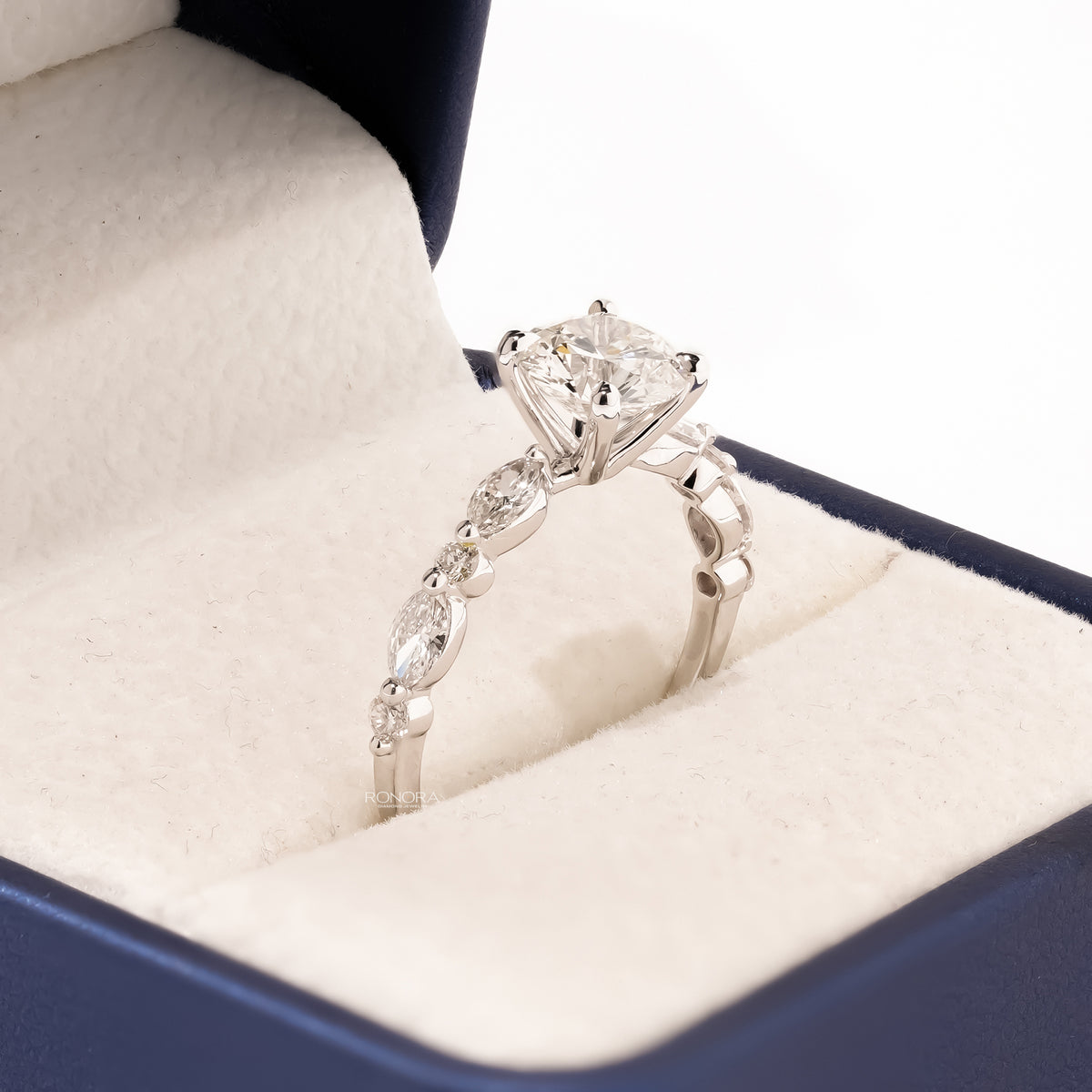 Angled view of round lab grown diamond side-stone ring with side-stone setting