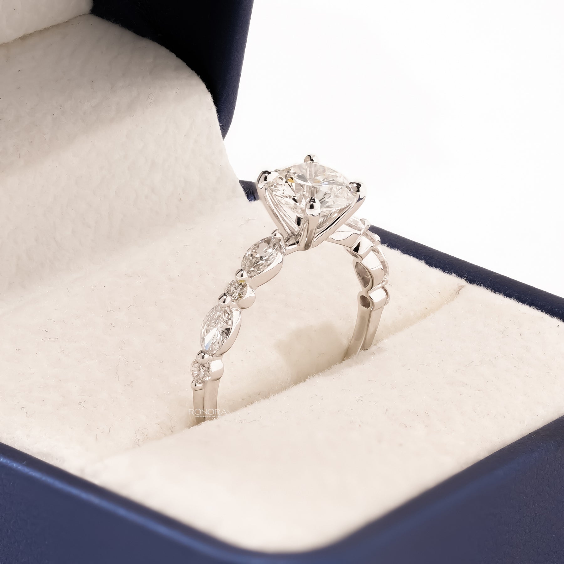 Angled view of round lab grown diamond side-stone ring with side-stone setting