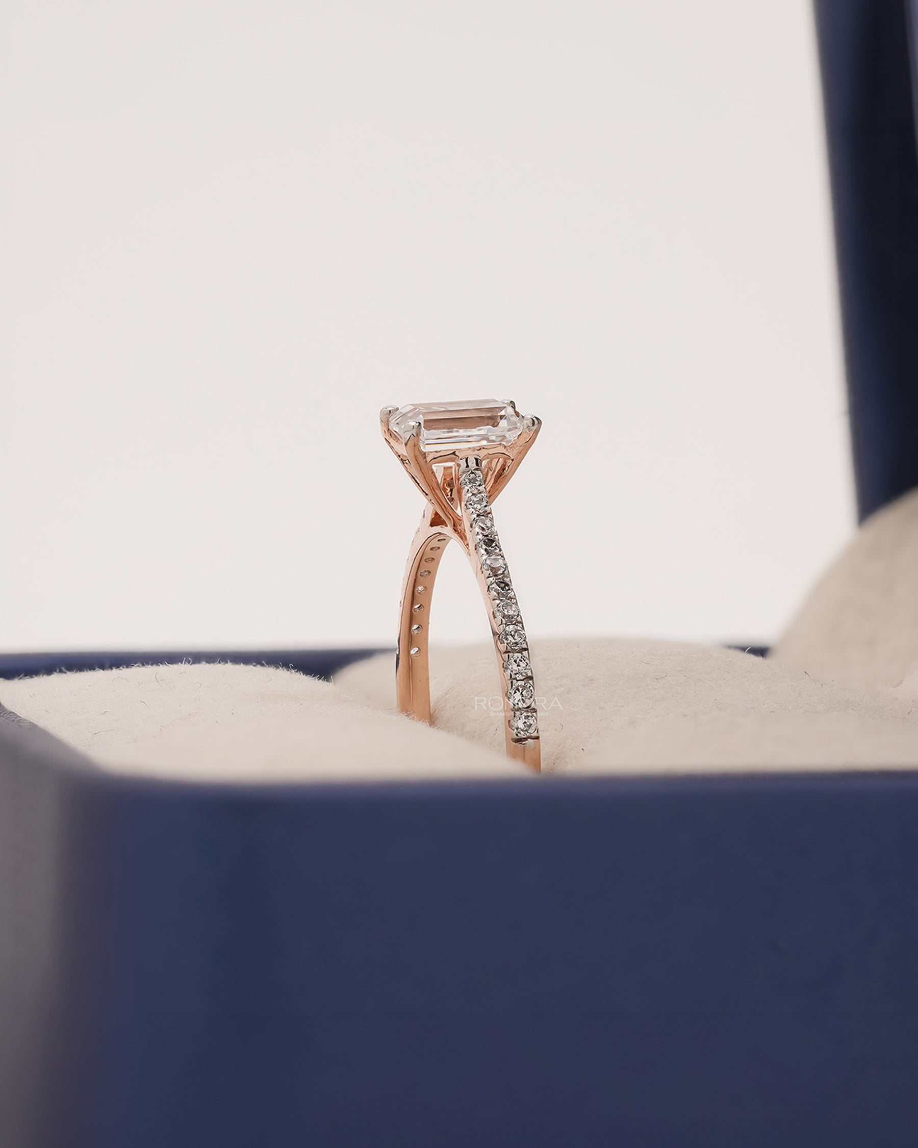 Side profile of emerald cut moissanite pave ring showing ring setting