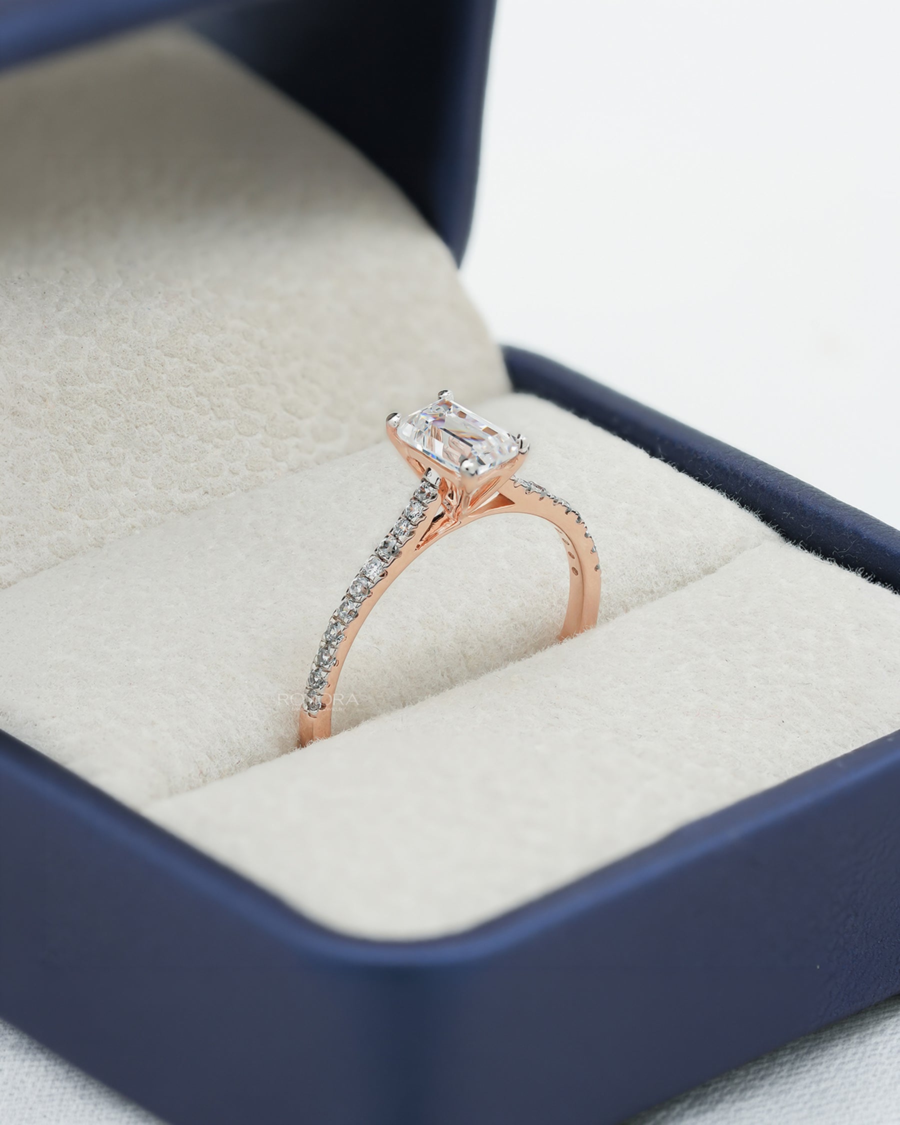 emerald cut moissanite pave ring worn with luxury styling in rose gold