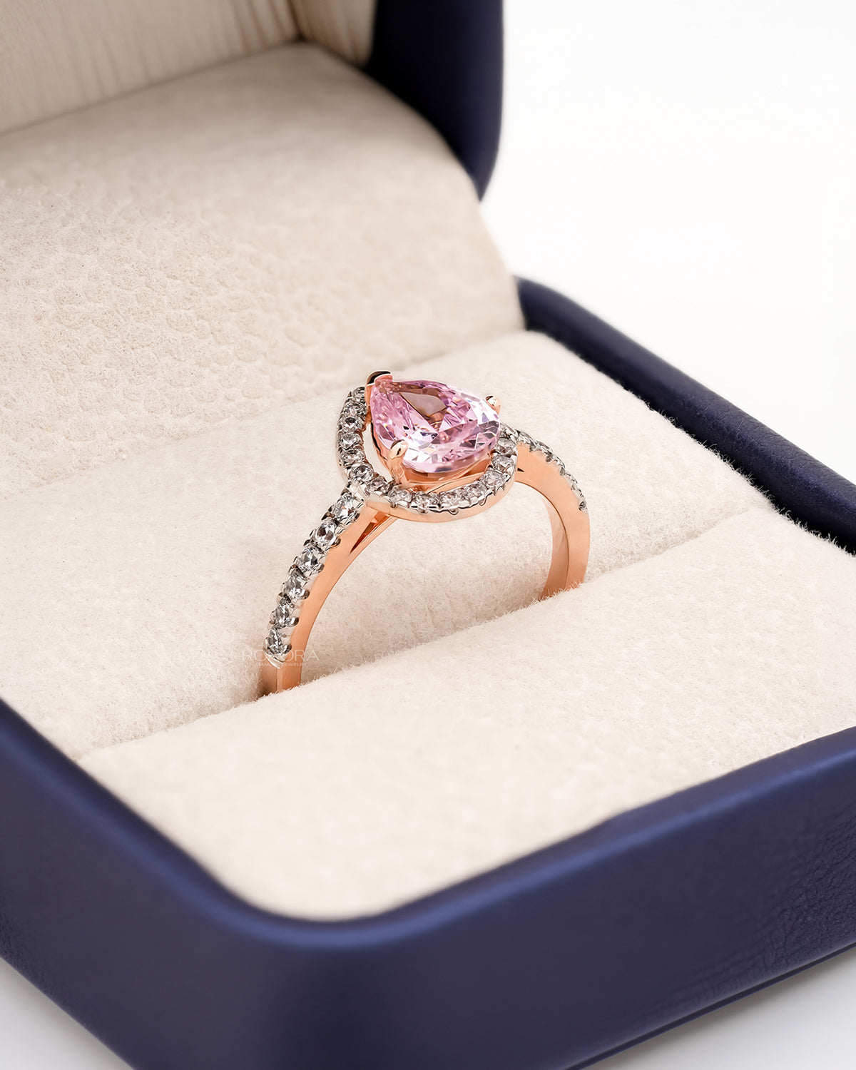 Angled view of pink pear moissanite halo ring with halo pave setting