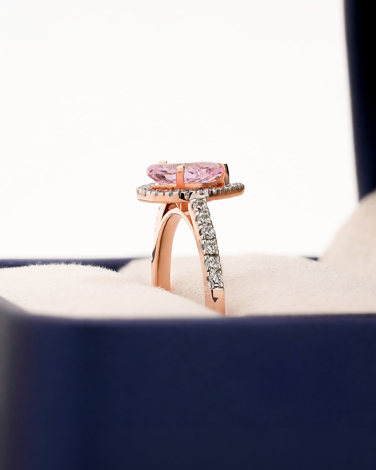 Side profile of pink pear moissanite halo ring showing ring setting