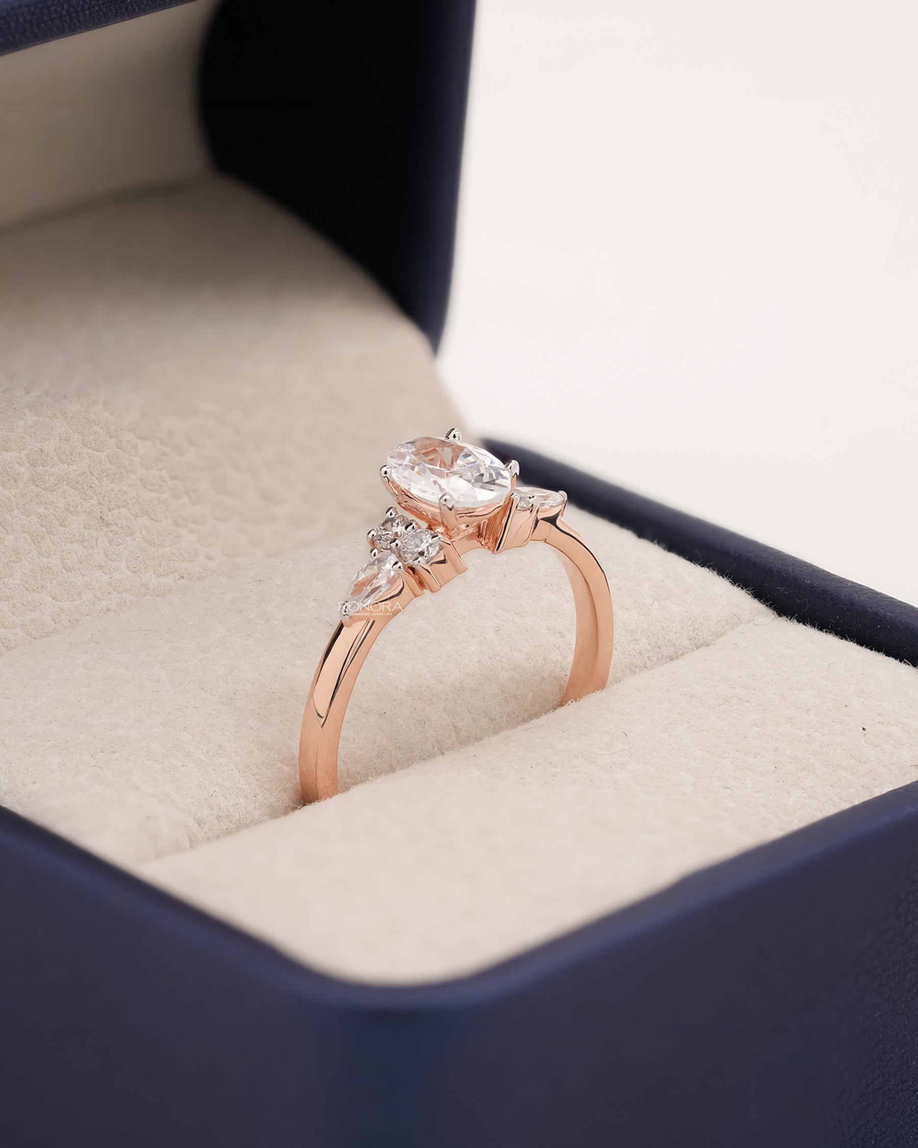 Angled view of oval pear moissanite cluster ring with cluster setting