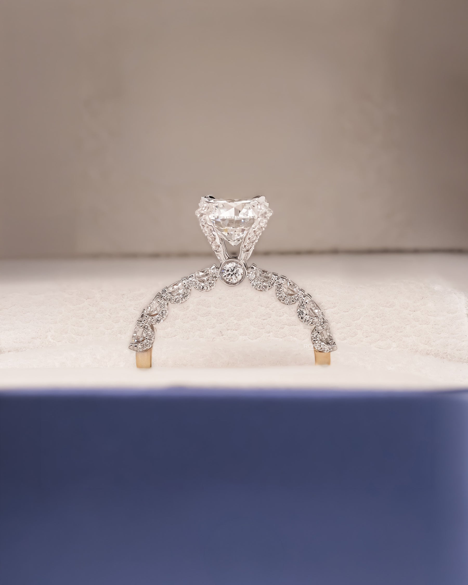 Angled view of round lab grown diamond side-stone ring with side-stone setting