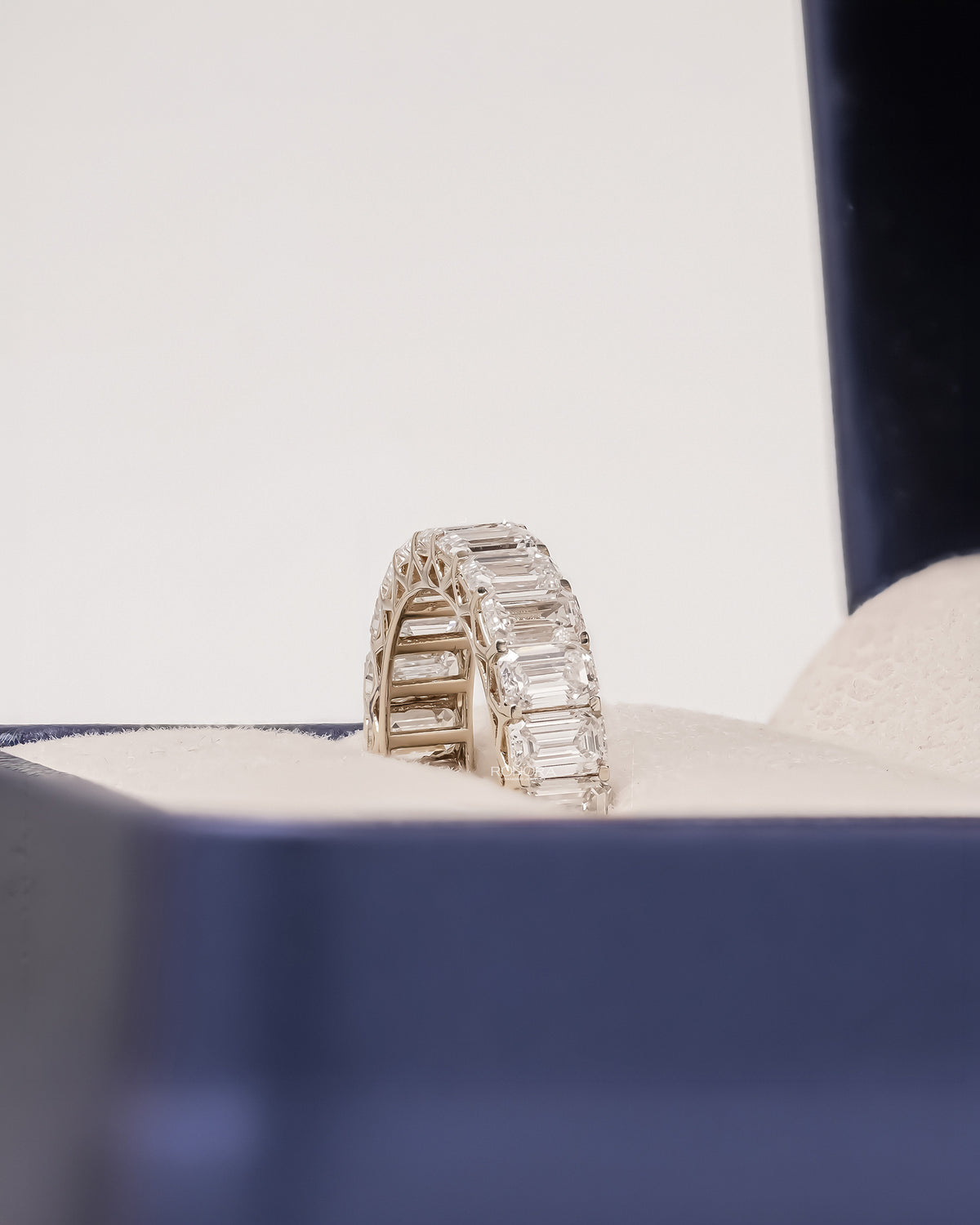 Angled view of emerald lab grown diamond eternity band with eternity setting