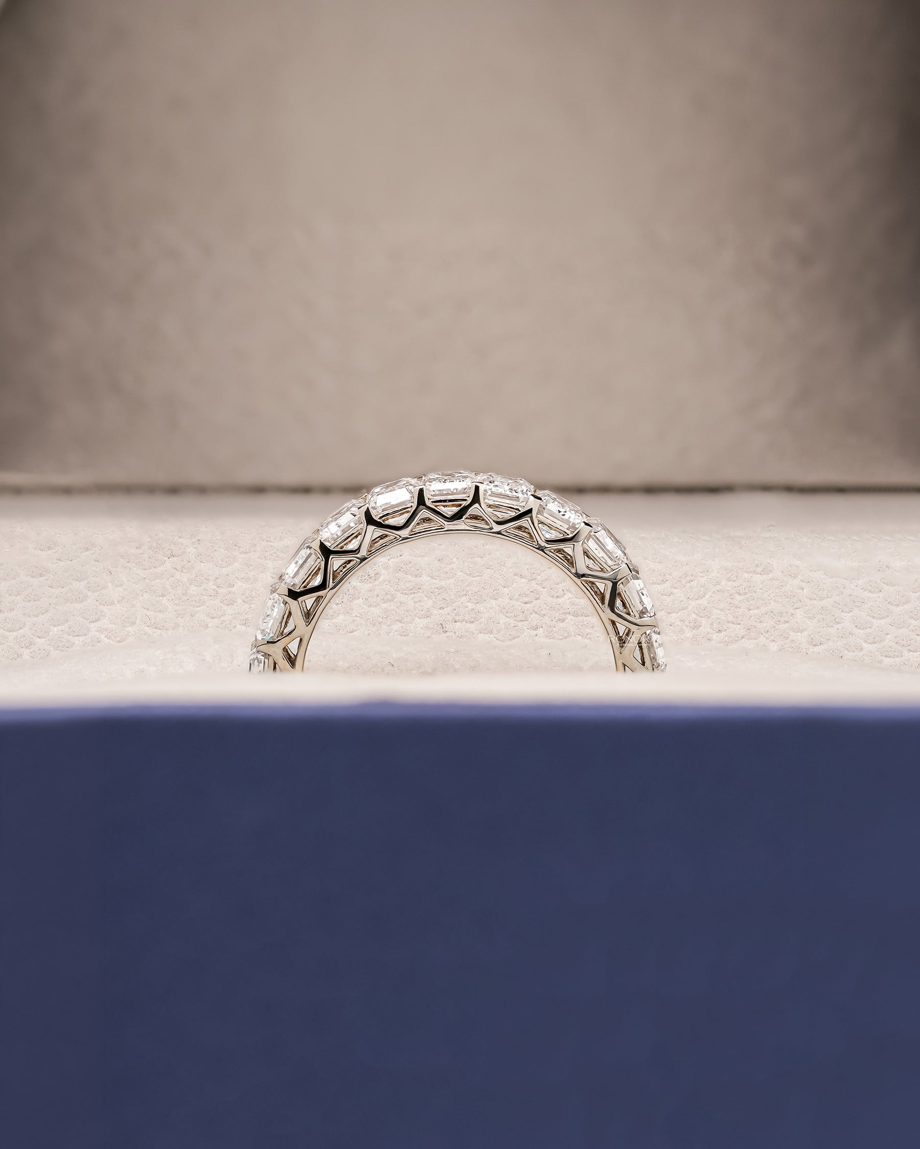 Side profile of emerald lab grown diamond eternity band showing ring setting