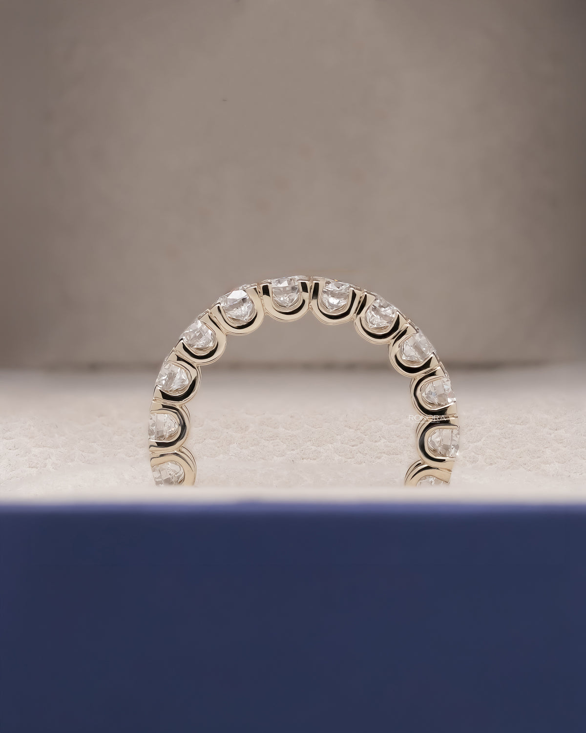 Angled view of round lab grown diamond eternity band with eternity setting