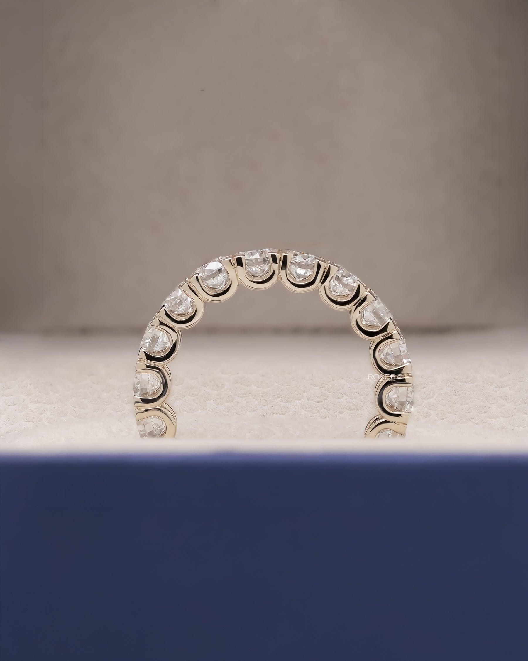 Angled view of round lab grown diamond eternity band with eternity setting