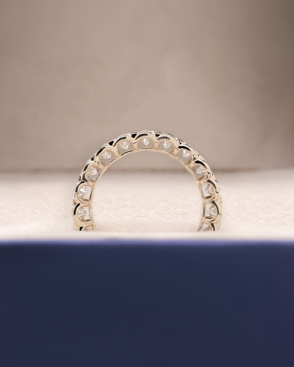 Angled view of oval lab grown diamond eternity band with eternity setting