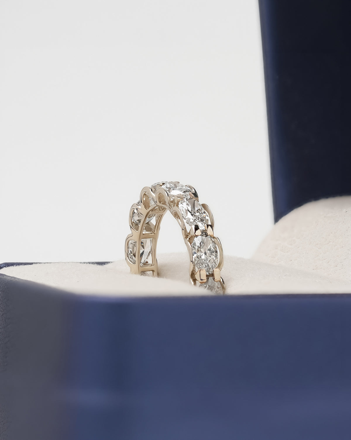 Angled view of oval lab grown diamond eternity band with eternity setting