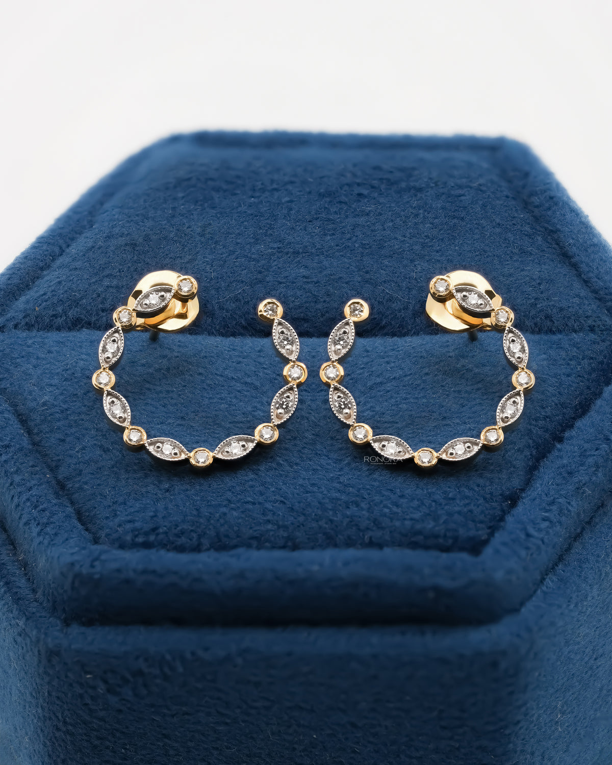 Pair of open circle lab grown diamond earrings with marquise accents in a blue velvet jewelry box