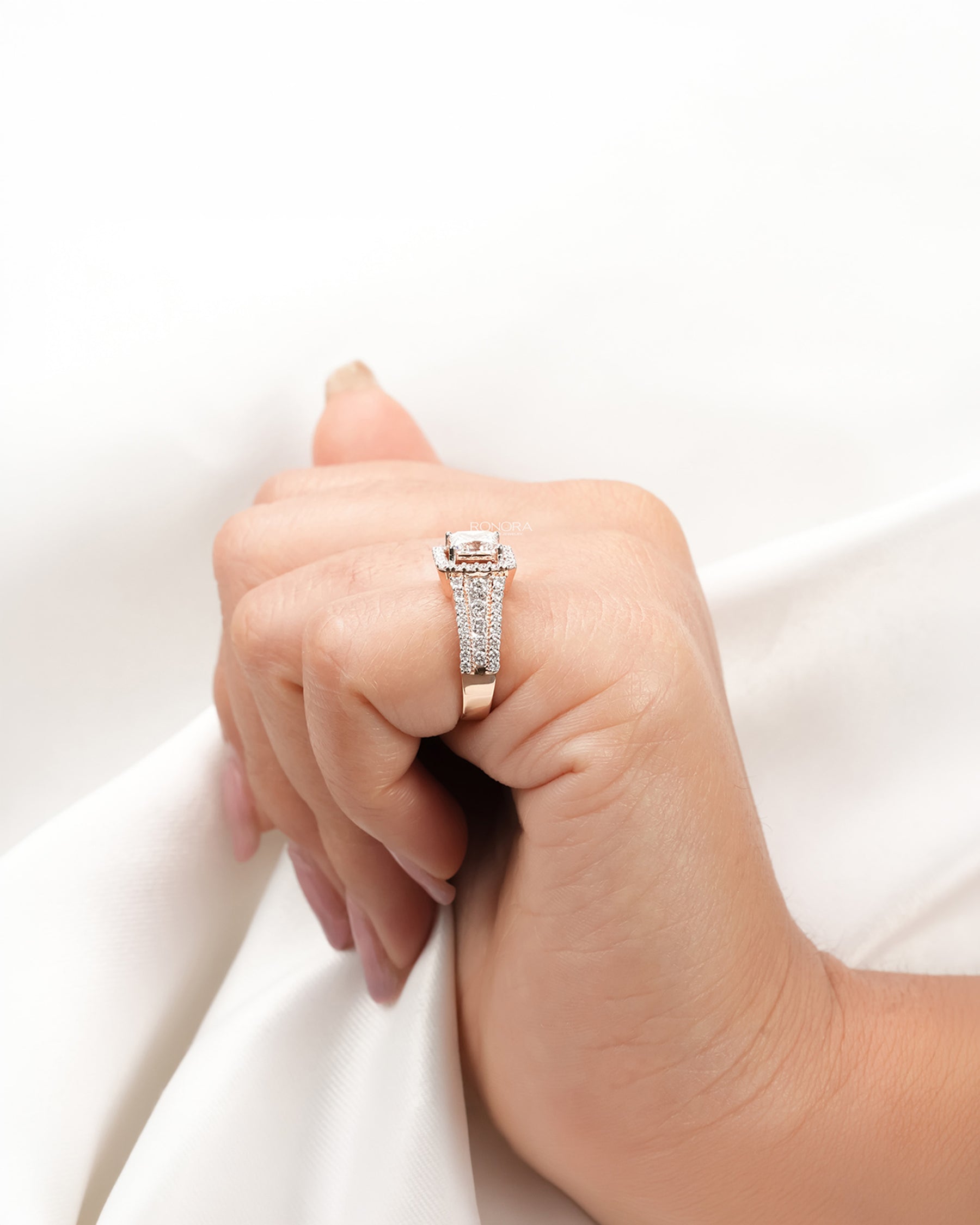 princess lab grown diamond halo ring worn with luxury styling in rose gold