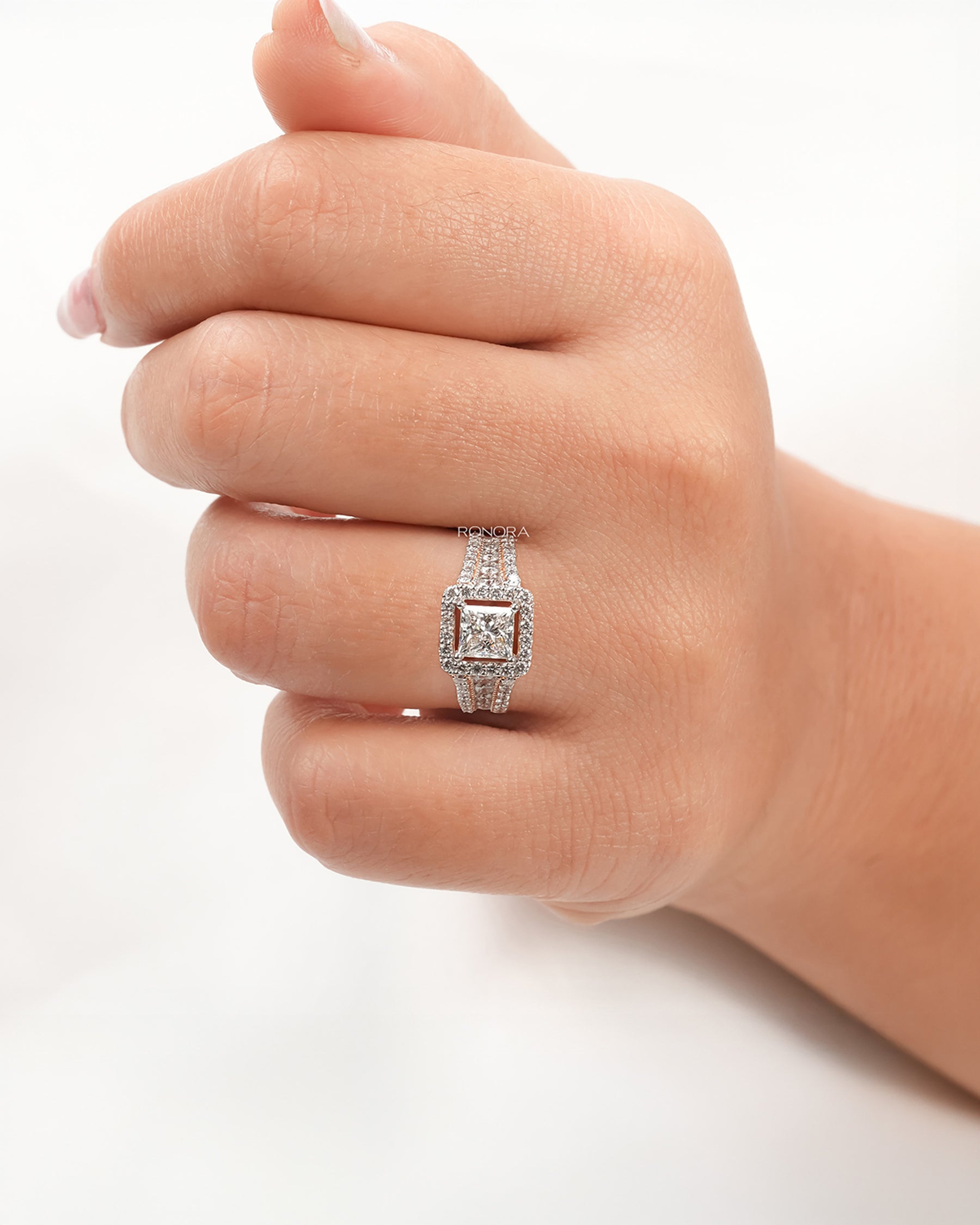 princess lab grown diamond halo ring worn on hand in rose gold