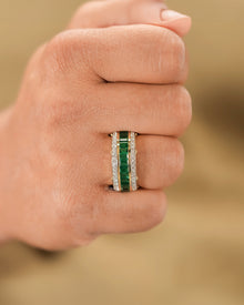 Green lab grown diamond channel band worn on hand in yellow gold