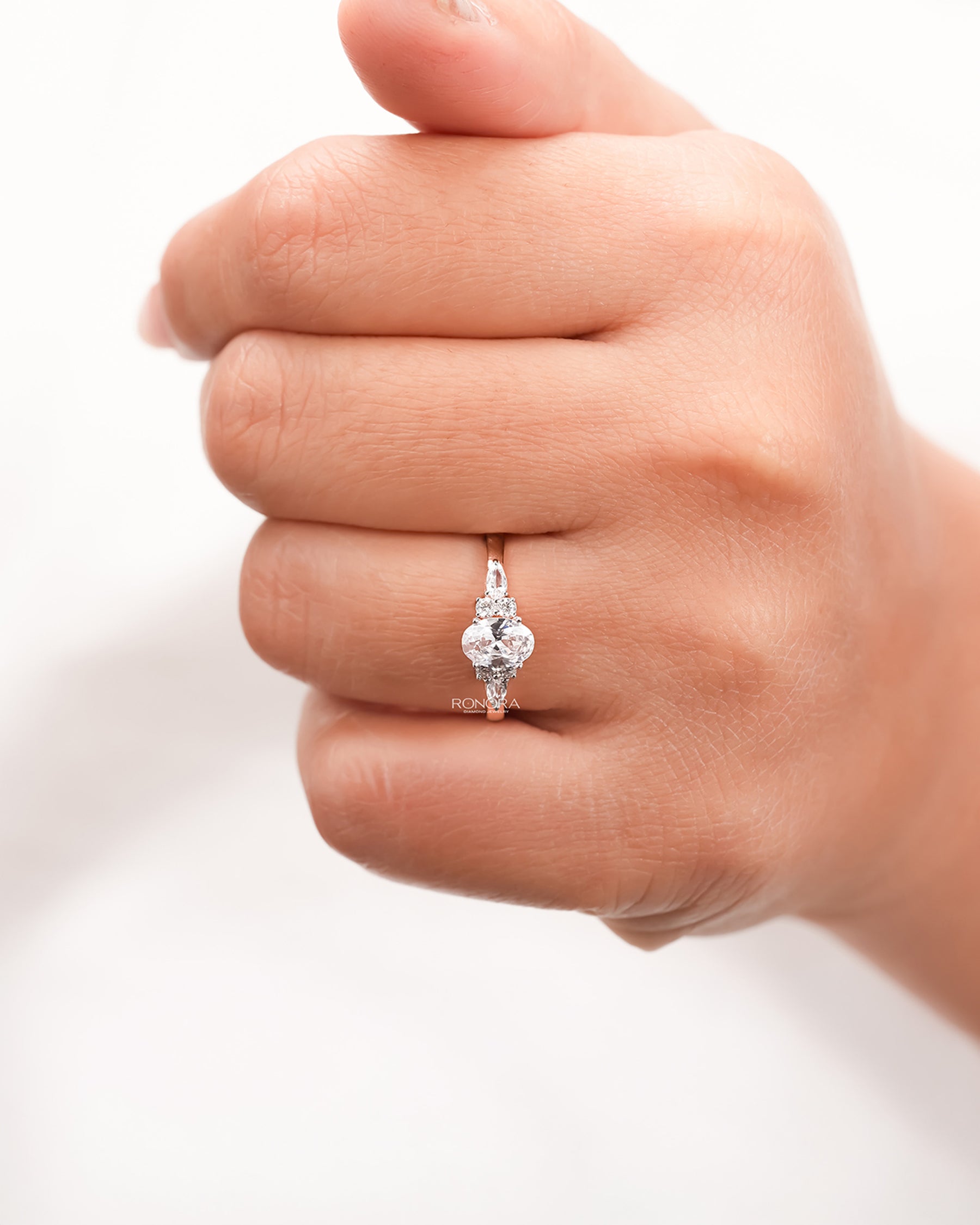 oval pear moissanite cluster ring worn on hand in rose gold