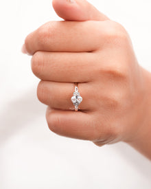 oval pear moissanite cluster ring worn on hand in rose gold
