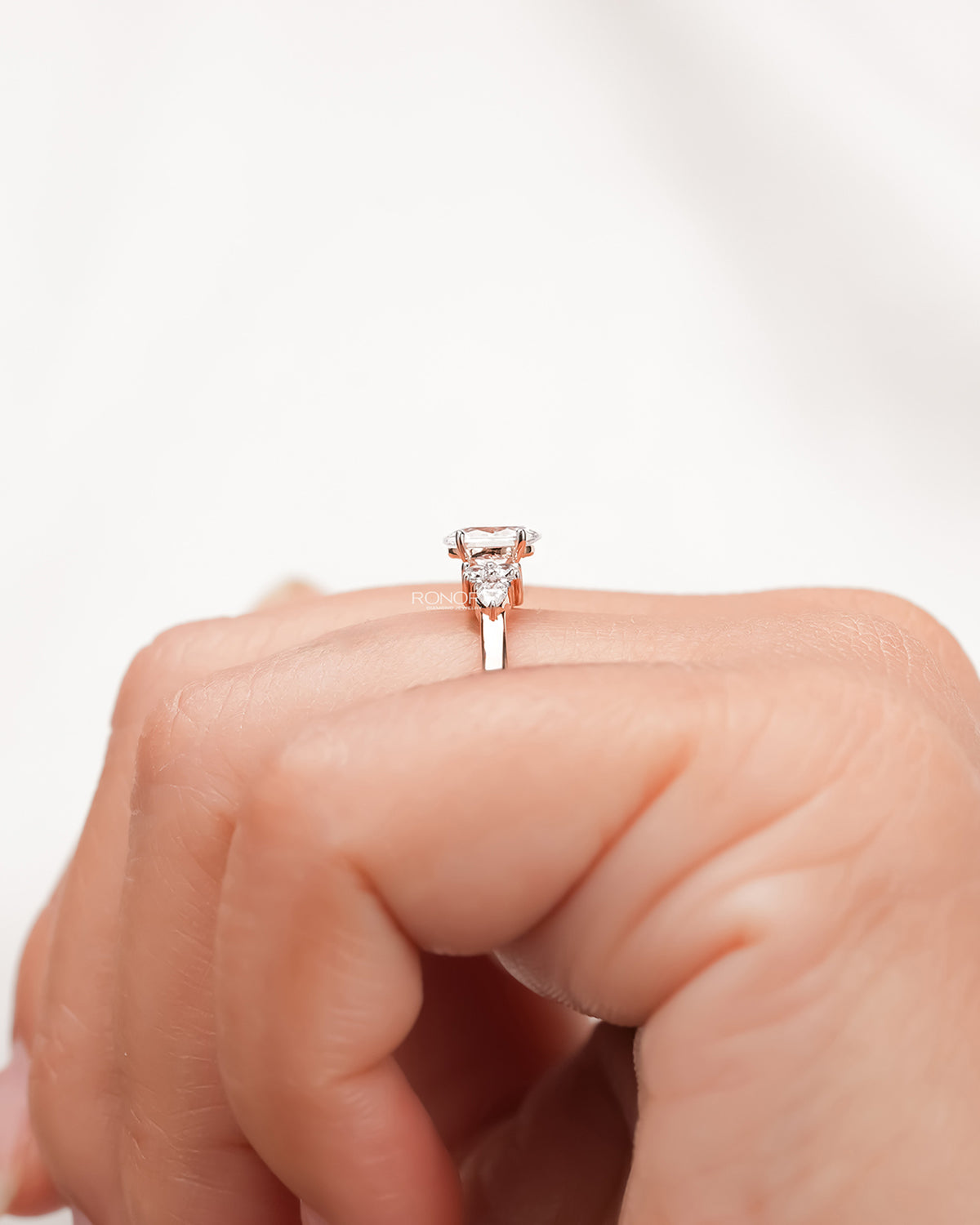 oval pear moissanite cluster ring worn with luxury styling in rose gold